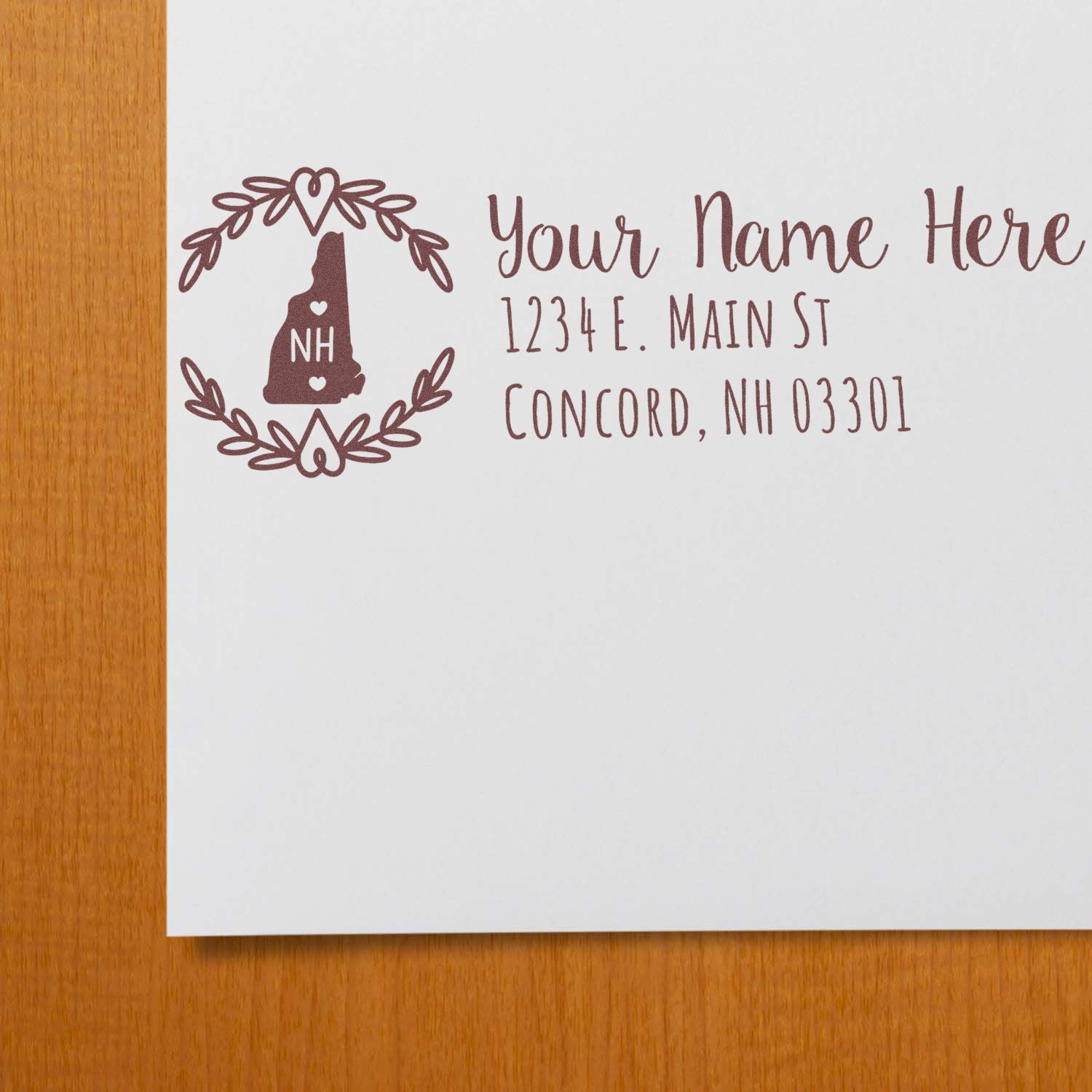 Custom New Hampshire return address rubber stamp with floral wreath and NH silhouette, ideal for personalized mail and invitations.