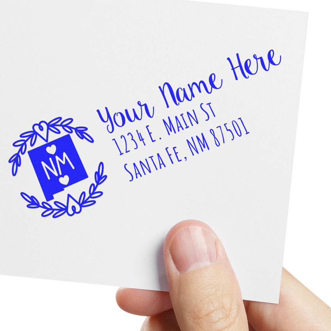 Custom return address rubber stamp with monogram logo and blue ink, showing name and Santa Fe, NM address on envelope.