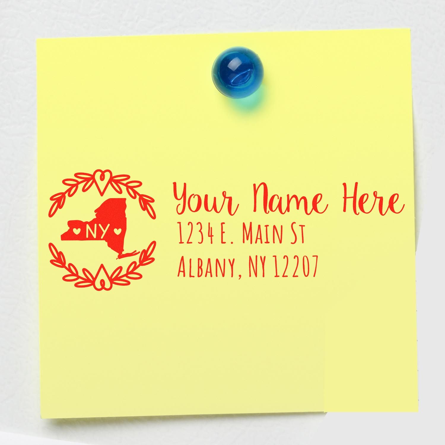 Personalized return address rubber stamp with New York state design and Albany, NY address on a yellow note.