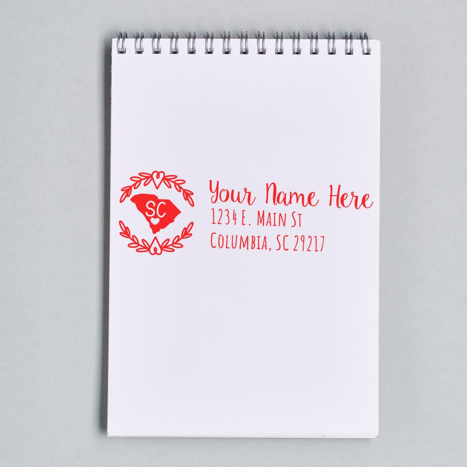 Custom return address rubber stamp with South Carolina design, personalized name, and Columbia, SC address on a notepad.