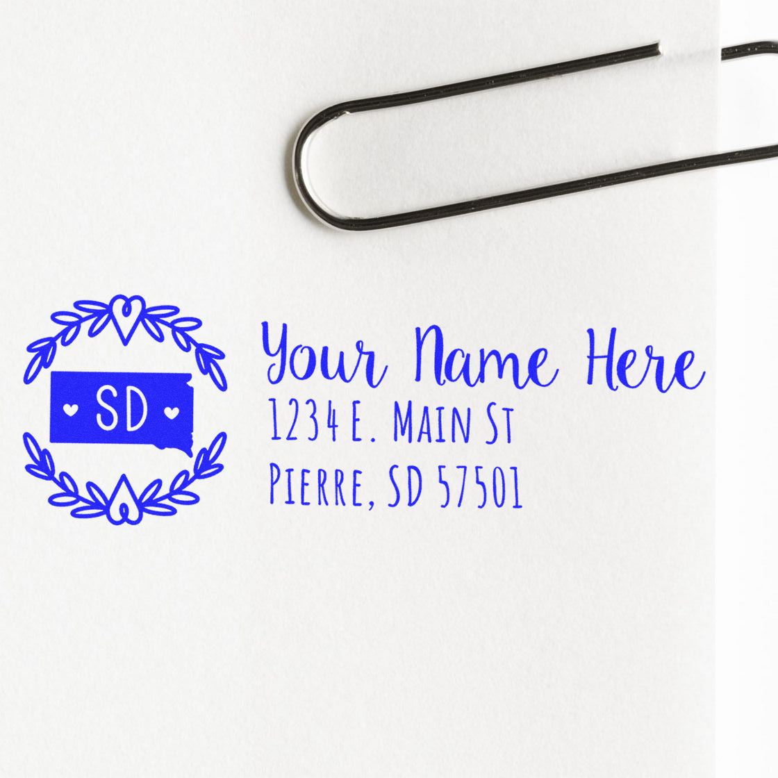 Personalized return address rubber stamp with South Dakota design and custom name and address in blue ink.