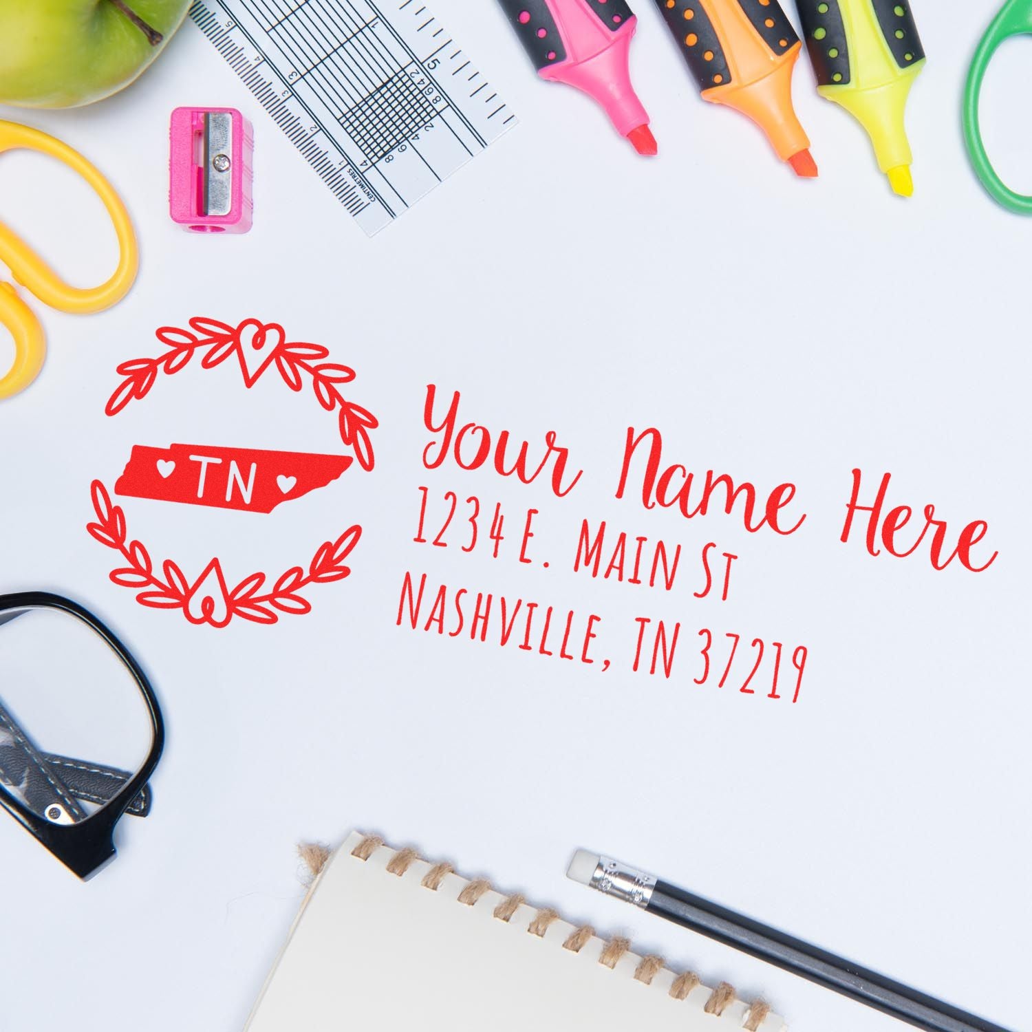 Custom return address rubber stamp design with monogram, surrounded by stationery tools for personalized mailing.