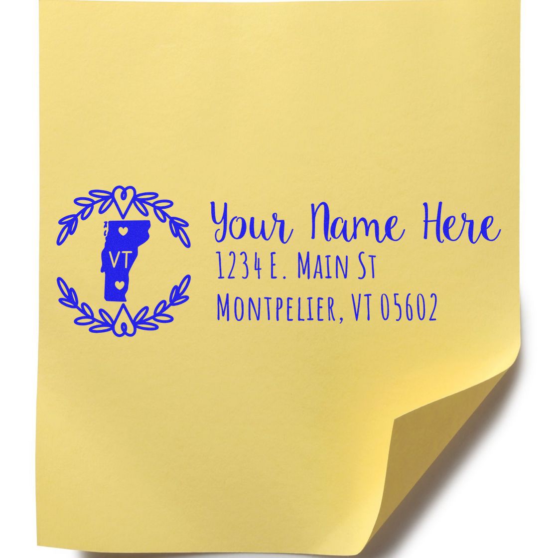 Personalized return address rubber stamp with Vermont monogram and floral wreath, showing name and address on yellow paper.