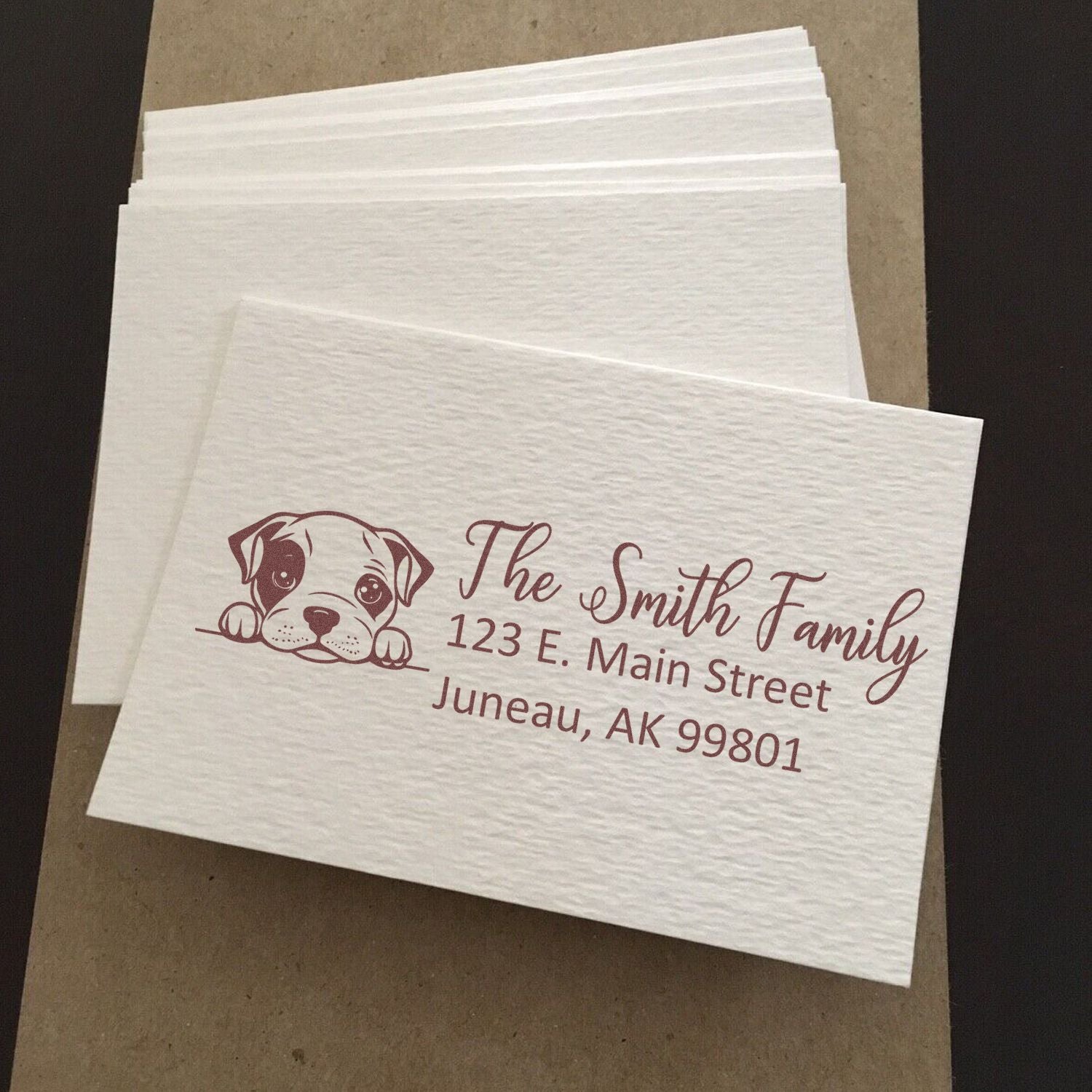 Custom rubber stamp on textured napkins with dog logo and personalized family return address for wedding or event use.