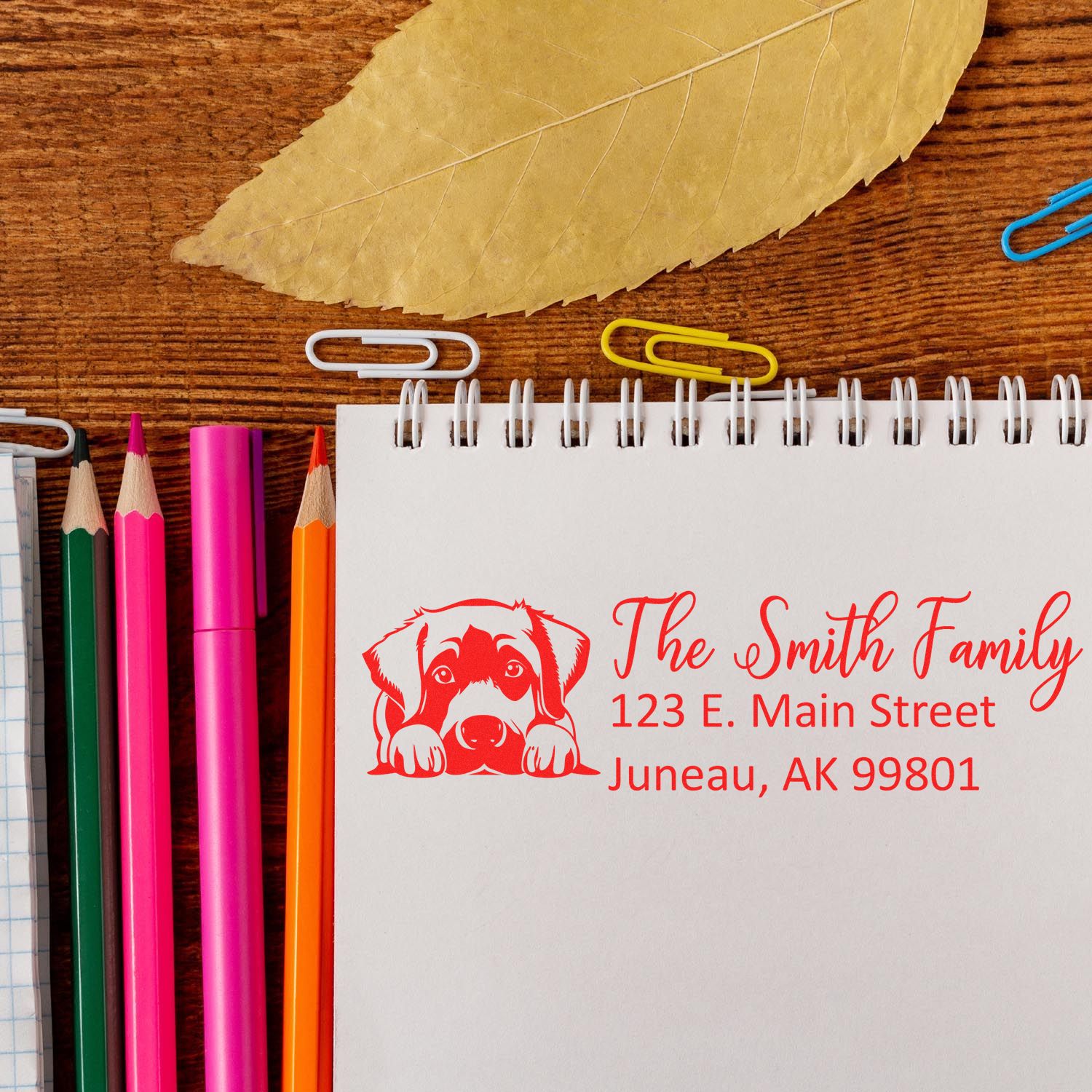 Custom return address rubber stamp with dog illustration, showing The Smith Family address on a notebook.