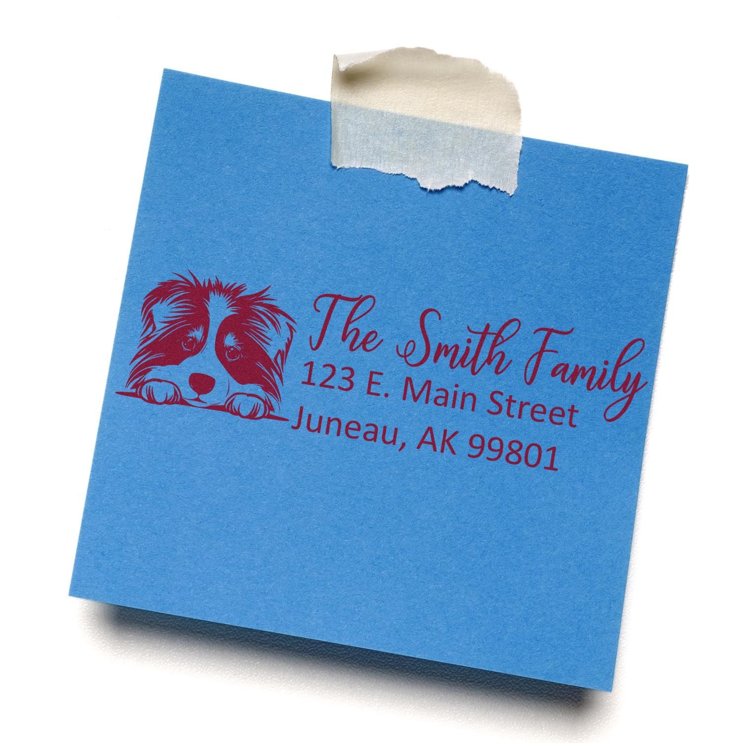 Personalized return address rubber stamp with dog design for The Smith Family, stamped on a blue note card.