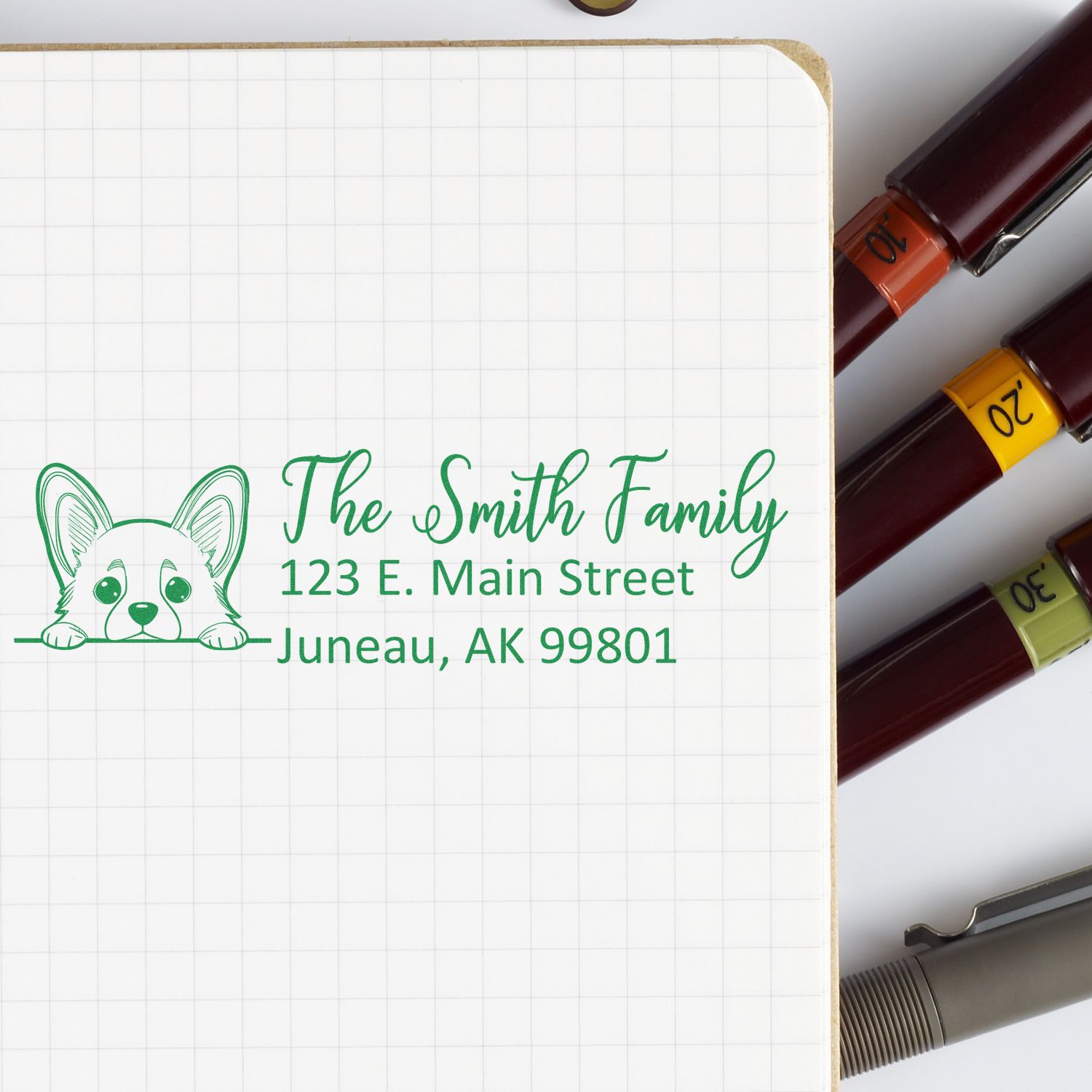 Personalized rubber address stamp with dog icon and Smith family return address, shown on notebook beside ink color options.
