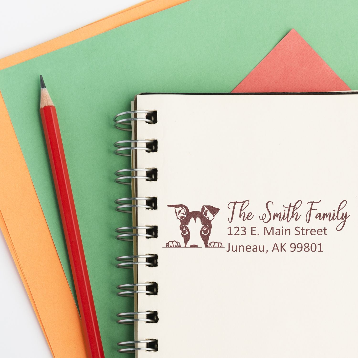 Personalized family address rubber stamp design with dog logo, stamped on a notebook for custom stationery and mailing.
