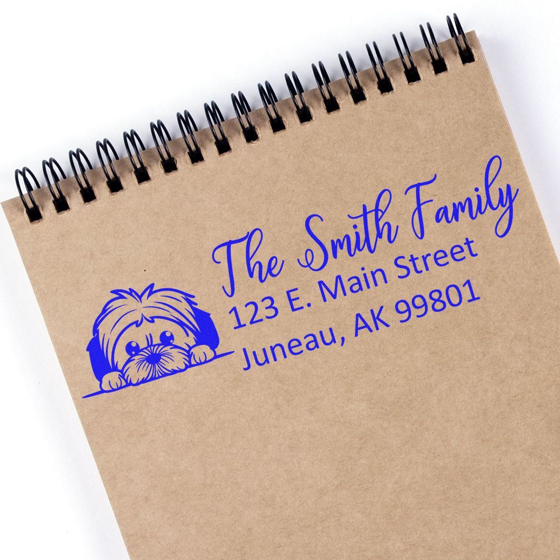 Personalized family address rubber stamp with dog logo, showing The Smith Family and Juneau, AK on kraft notebook.