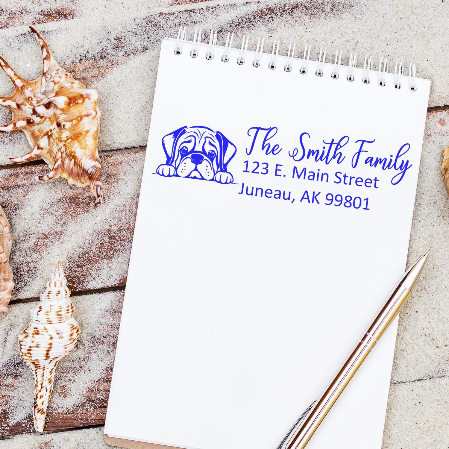 Personalized return address rubber stamp with bulldog logo for The Smith Family, blue ink on notebook.