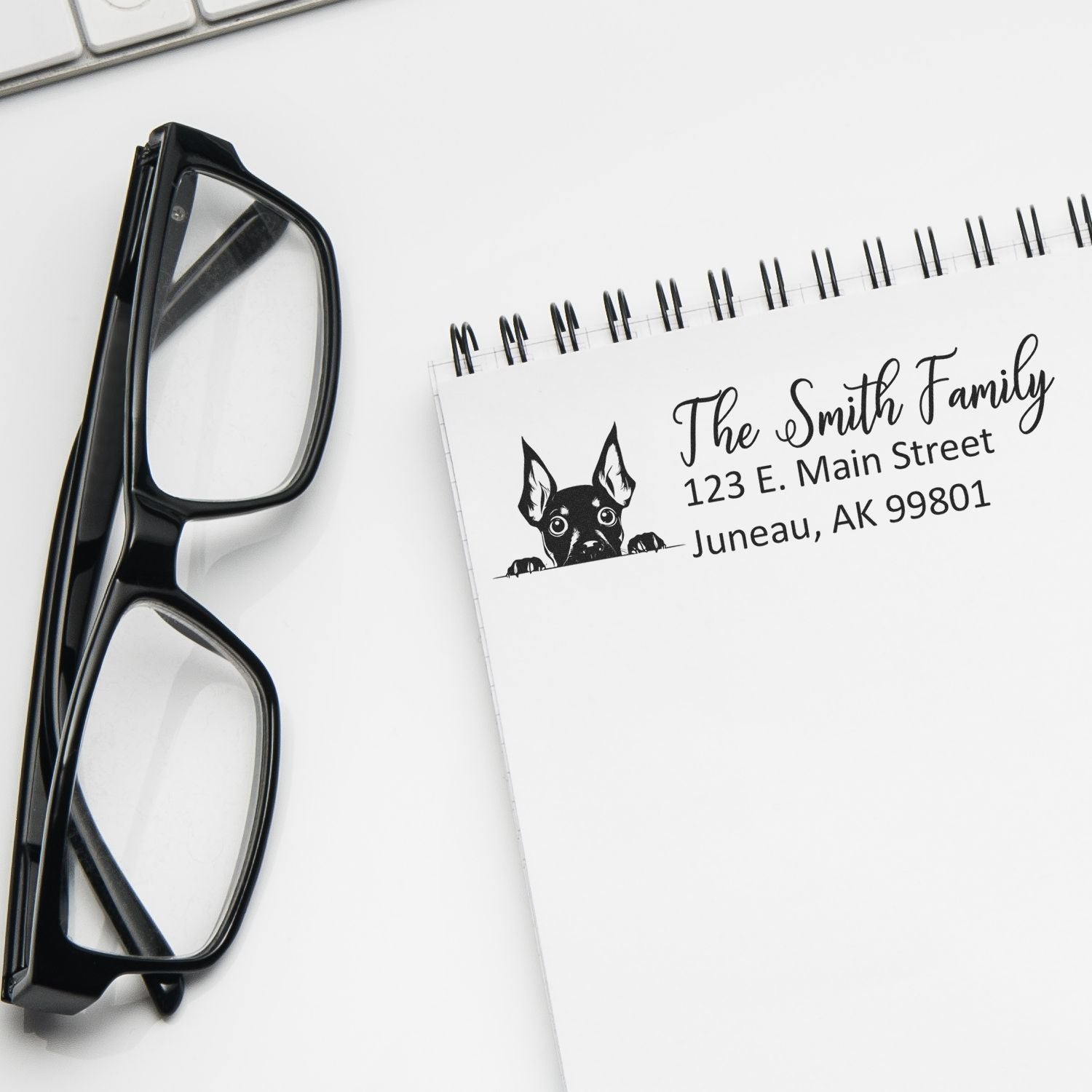 Personalized return address rubber stamp with dog logo on a white notebook.