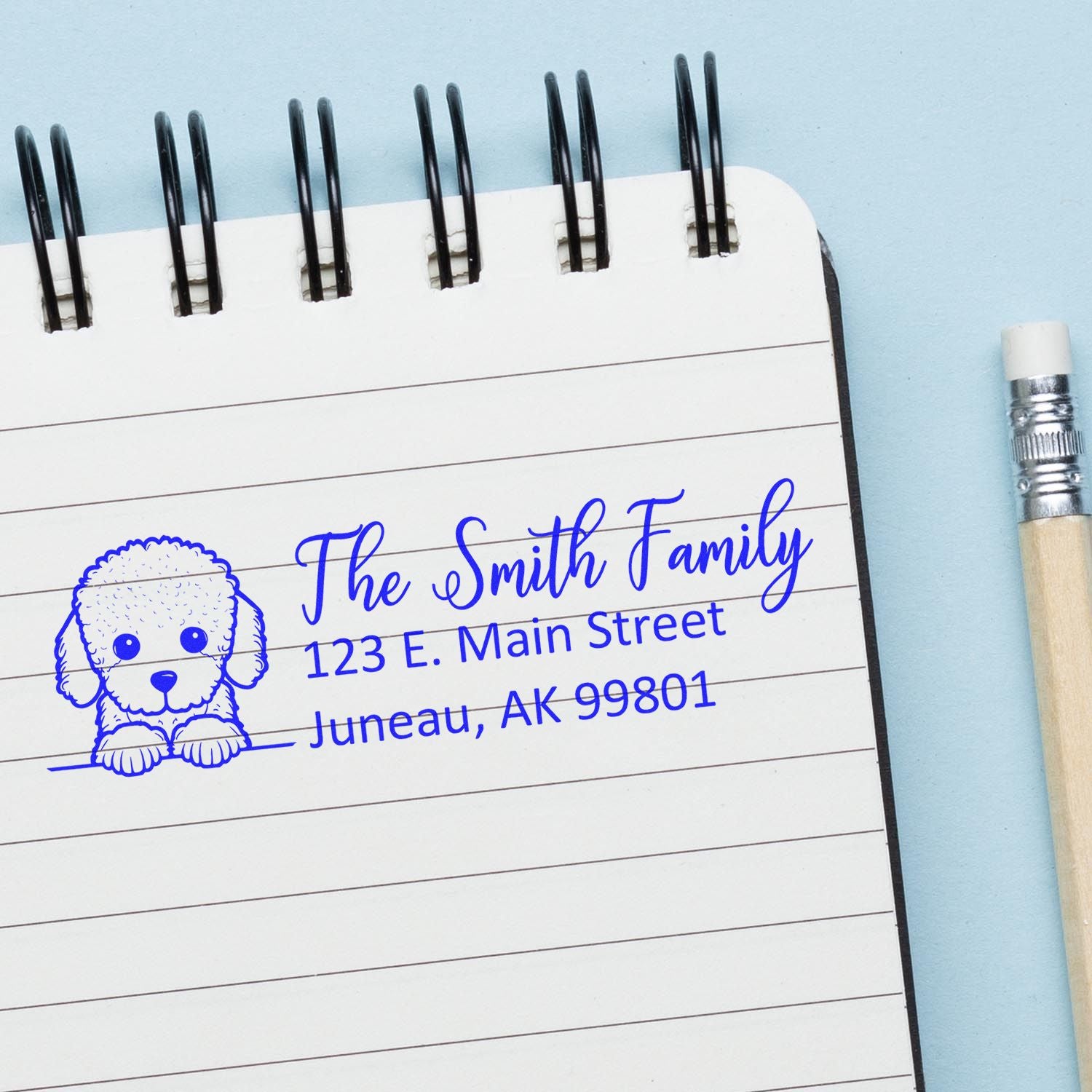 Custom rubber stamp with poodle design and Smith family return address stamped in blue on notebook paper.