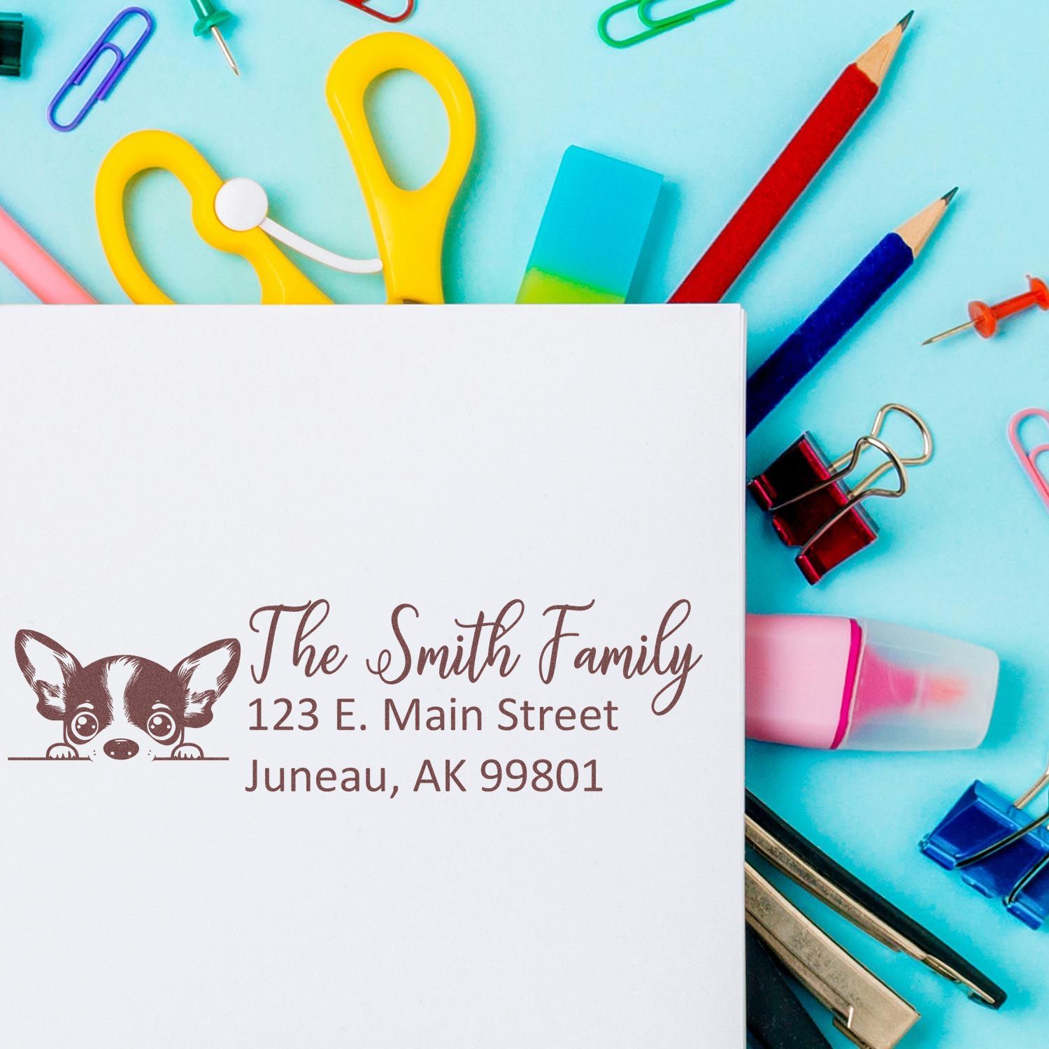 Custom rubber address stamp with dog illustration, The Smith Family name, and Juneau, AK address on stationery.