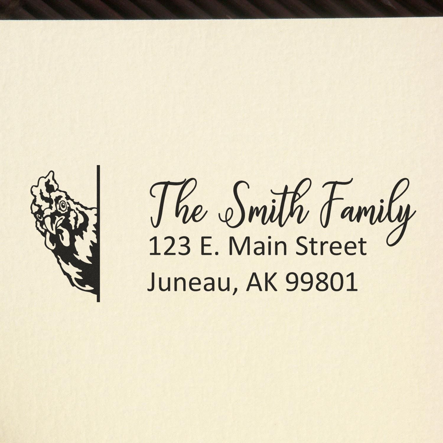 Custom return address rubber stamp with chicken illustration for The Smith Family, Juneau, AK 99801.