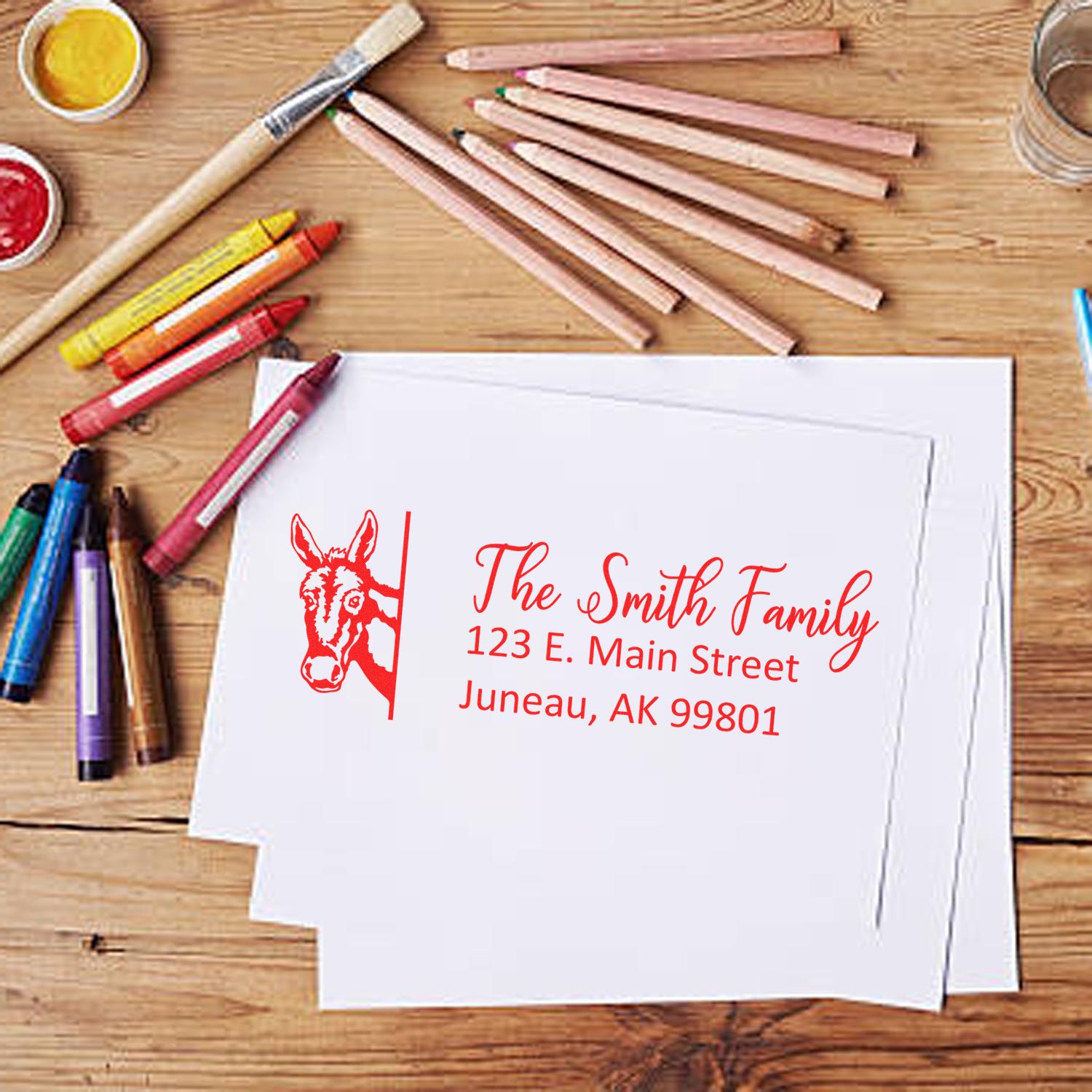 Custom address rubber stamp with donkey logo for The Smith Family, featuring Juneau, AK return address on paper.