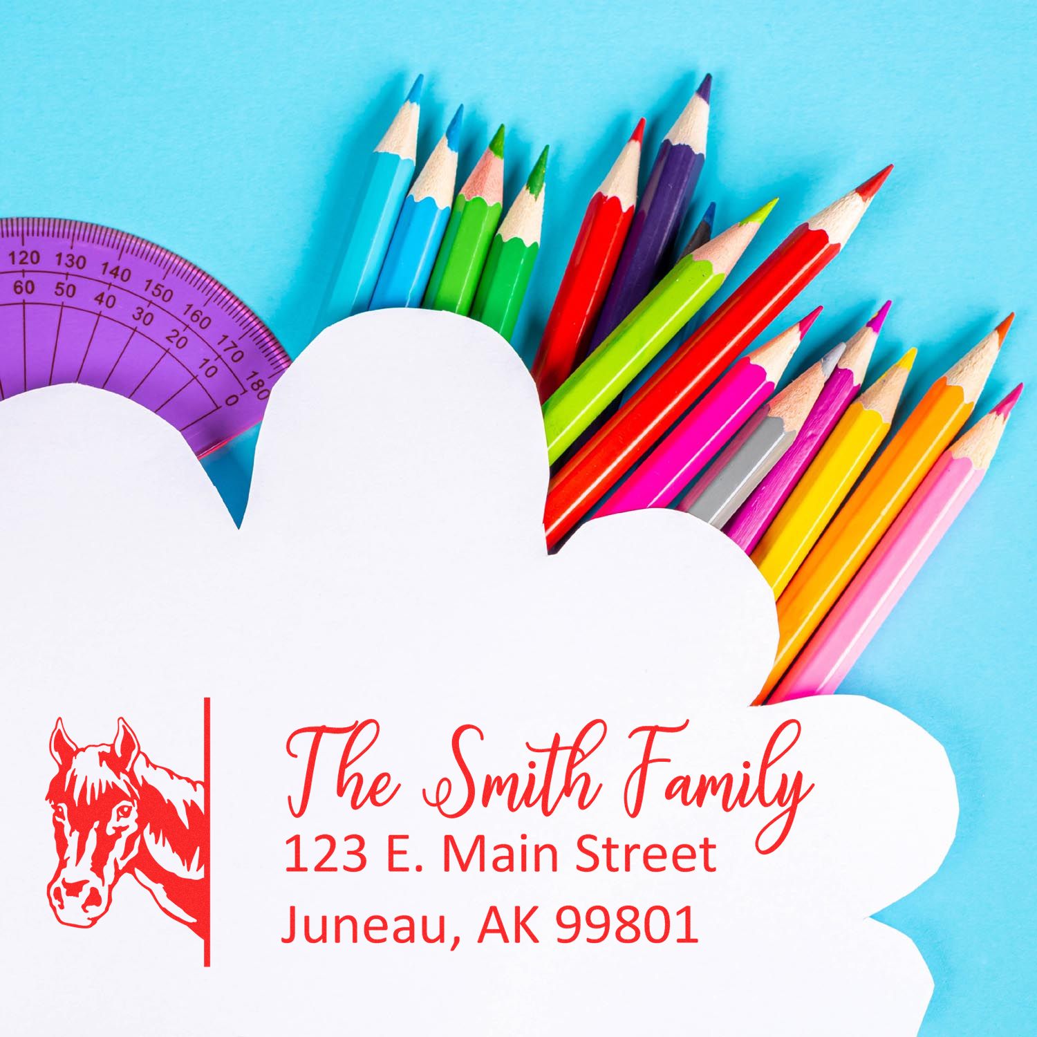 Personalized horse logo address rubber stamp for The Smith Family, shown with colorful pencils and a protractor.