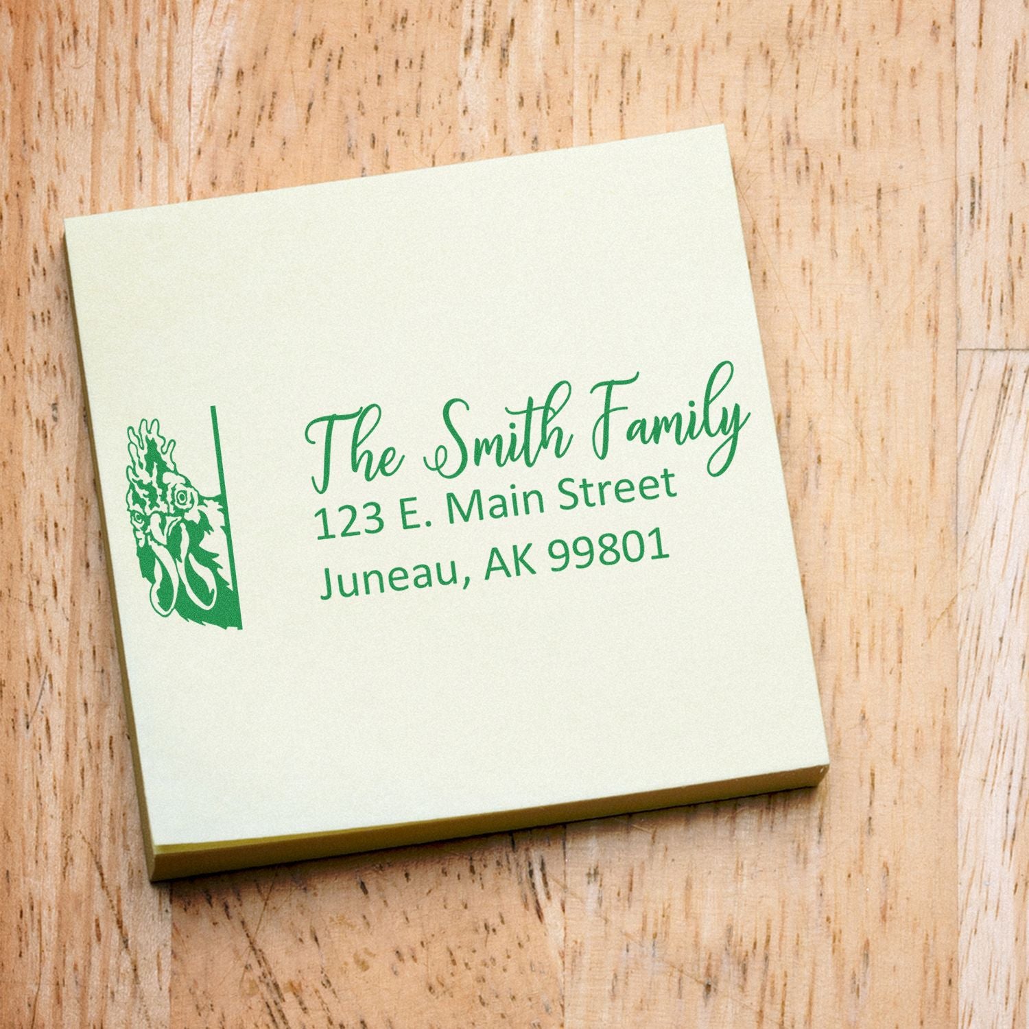 Custom rubber address stamp for The Smith Family with decorative graphic, personalized return address in green ink on a square card.