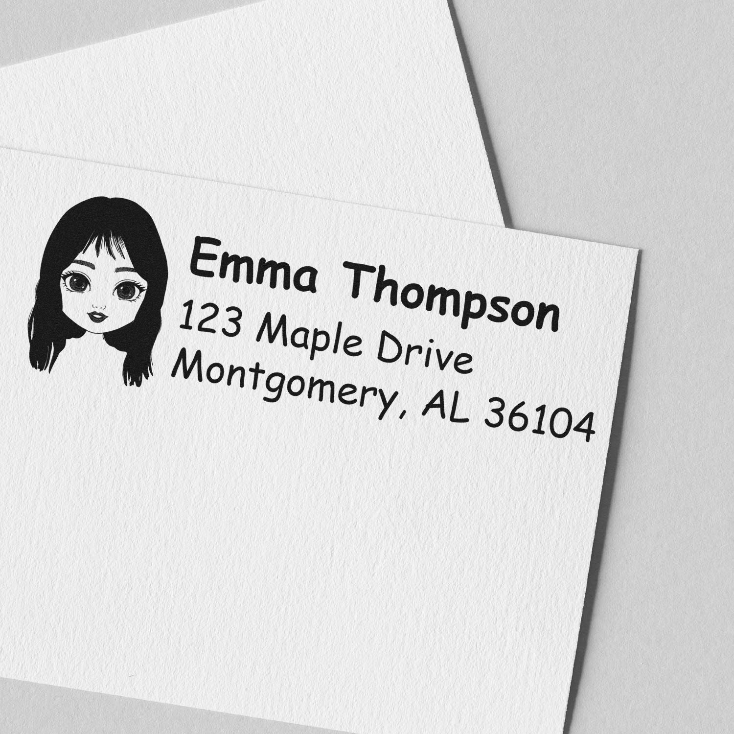 Personalized return address rubber stamp with illustrated girl and Emma Thompson address on a white envelope