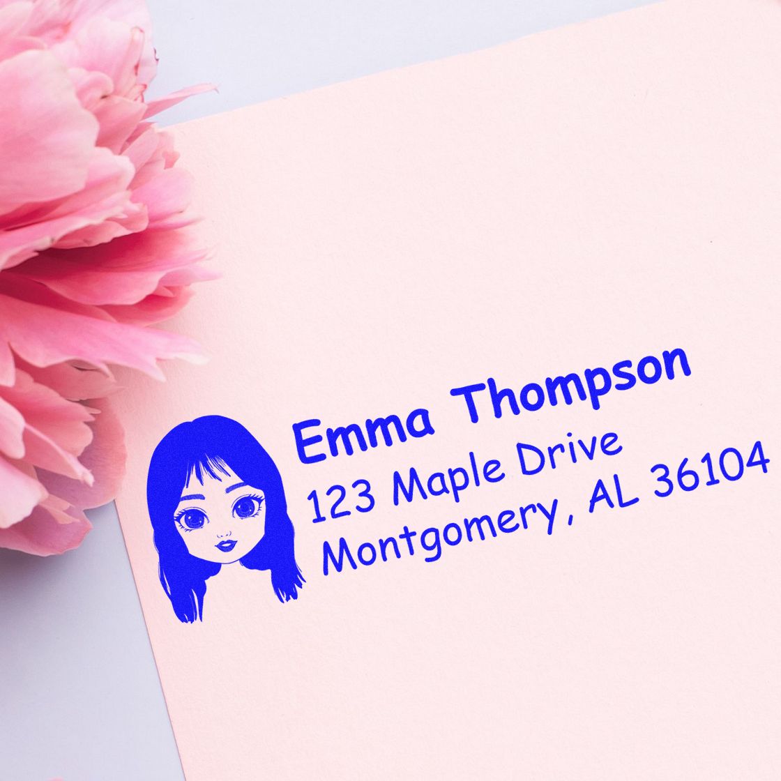 Custom return address rubber stamp with name, address, and avatar icon in blue ink for personalized stationery.