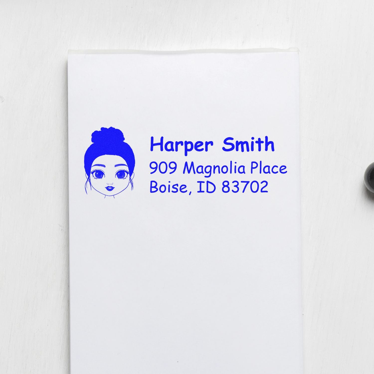 Blue custom return address rubber stamp with avatar for Harper Smith, 909 Magnolia Place, Boise, ID 83702.