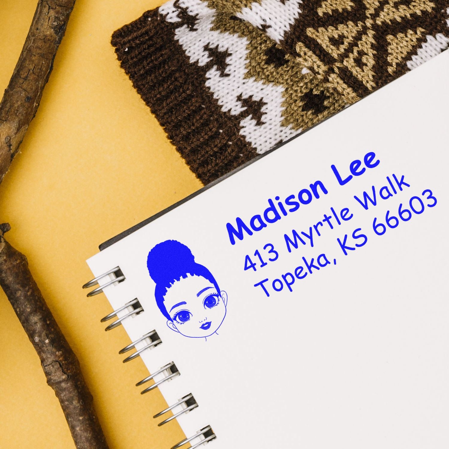 Personalized rubber address stamp with cartoon girl logo on spiral notebook for custom branding and mail labeling