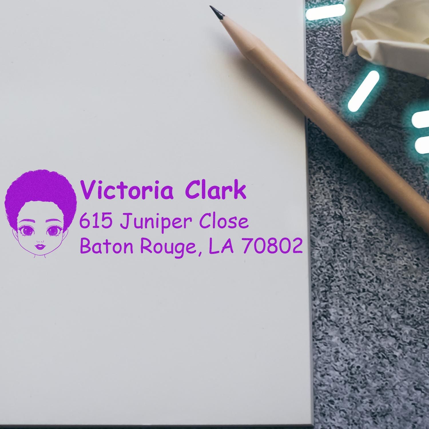 Personalized rubber address stamp with Victoria Clark name and Baton Rouge, LA 70802 in purple ink.