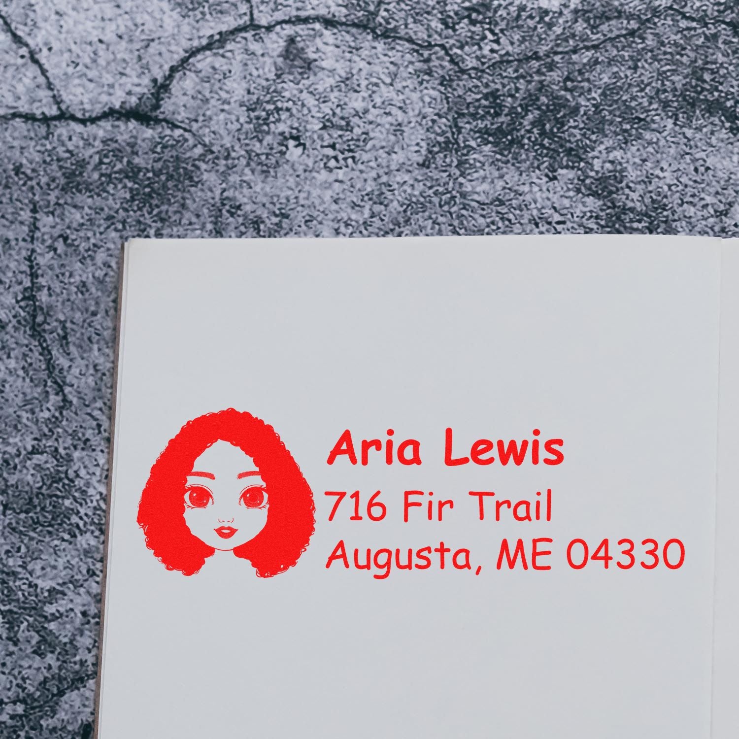 Custom return address rubber stamp with illustrated face, Aria Lewis, 716 Fir Trail, Augusta, ME 04330.