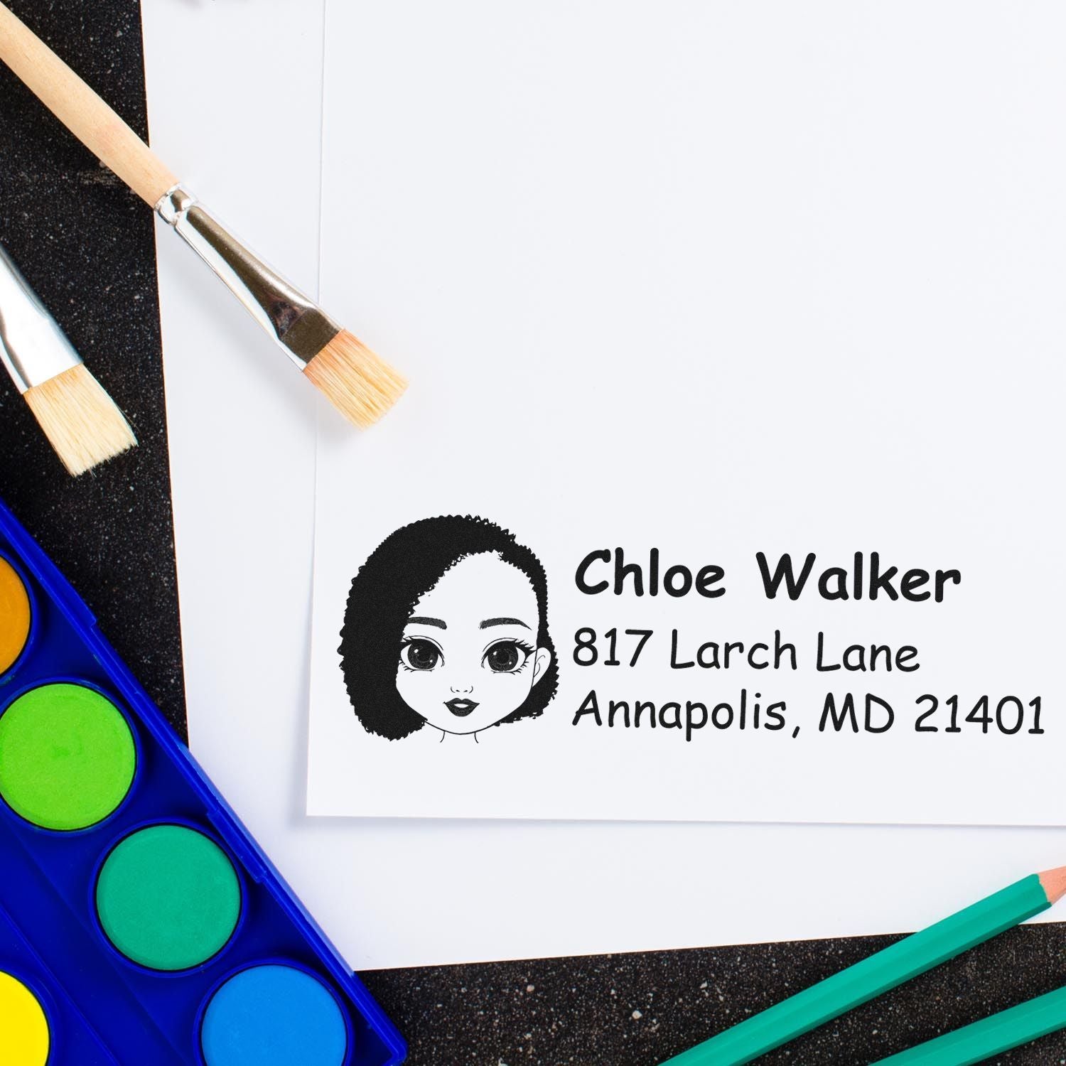 Personalized rubber return address stamp with illustrated portrait, name, and address for envelope mailing.
