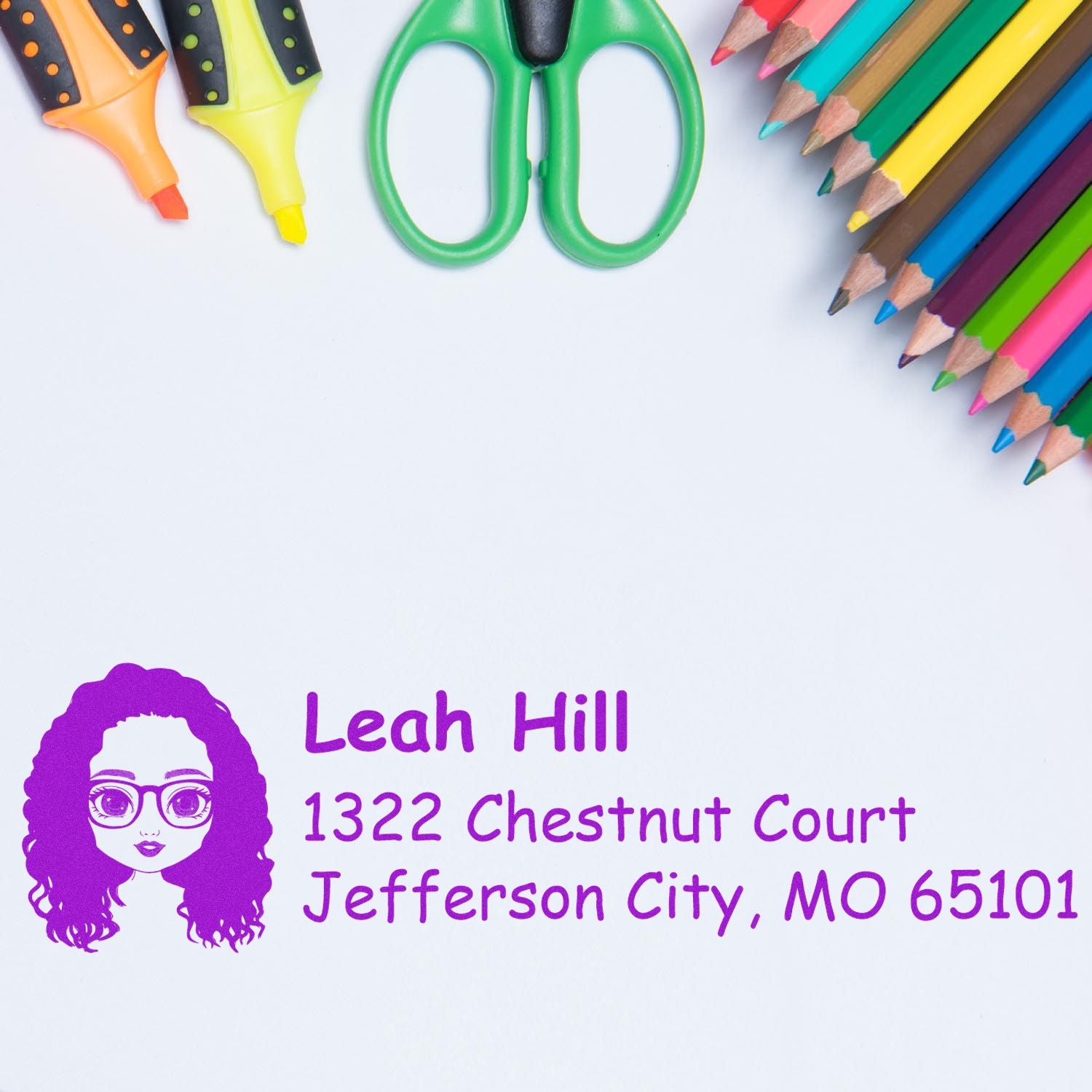 Custom return address rubber stamp for Leah Hill, Jefferson City, MO 65101, shown with colorful school supplies.