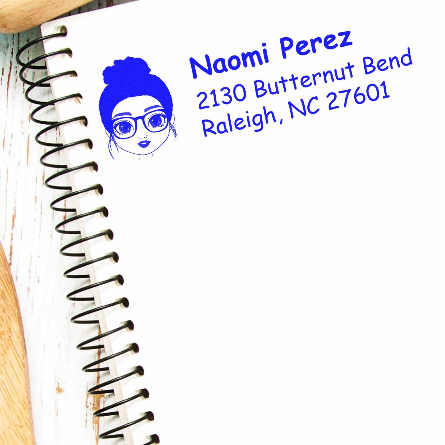 Custom return address rubber stamp with woman avatar for Naomi Perez, Raleigh, NC 27601 mailing labels.