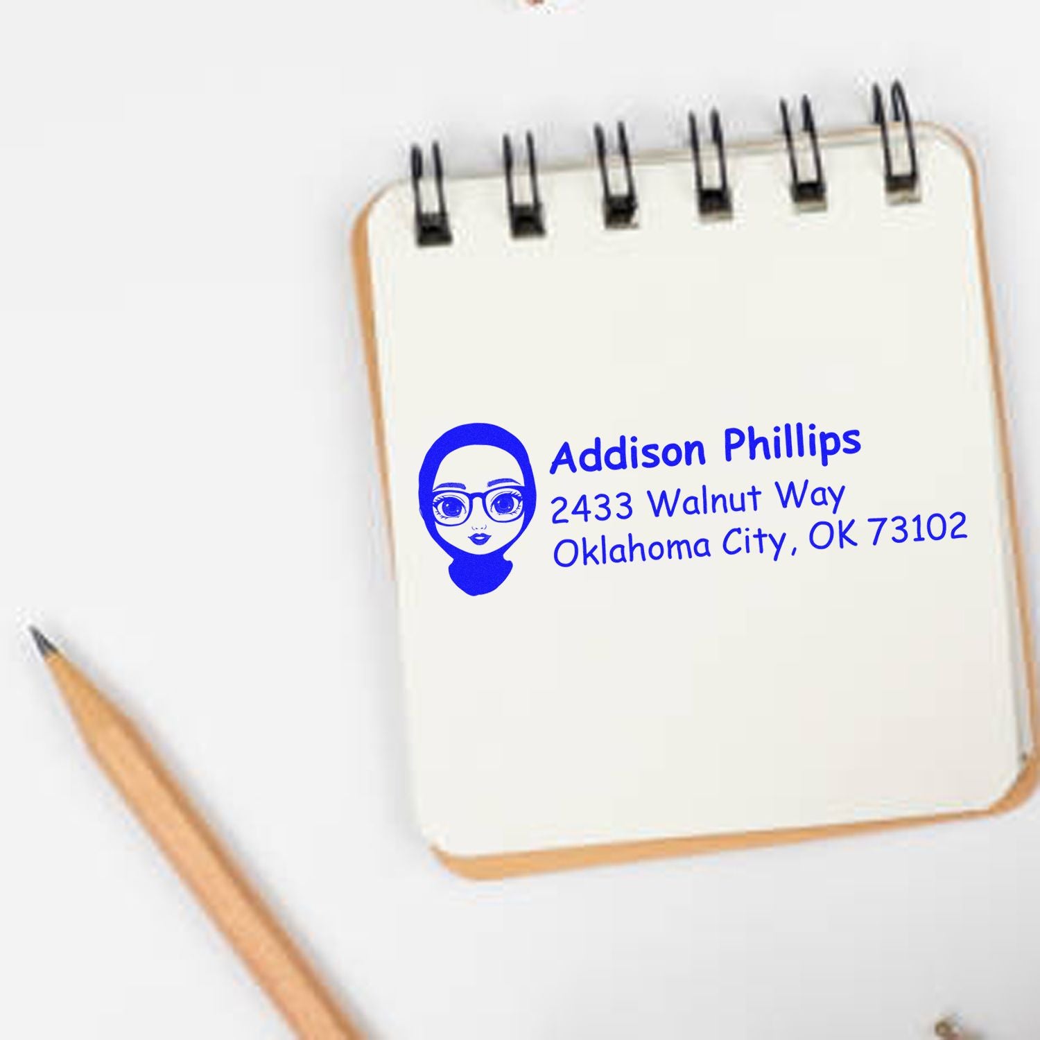 Custom return address rubber stamp for Addison Phillips with name, avatar, and Oklahoma City address on a notebook page.