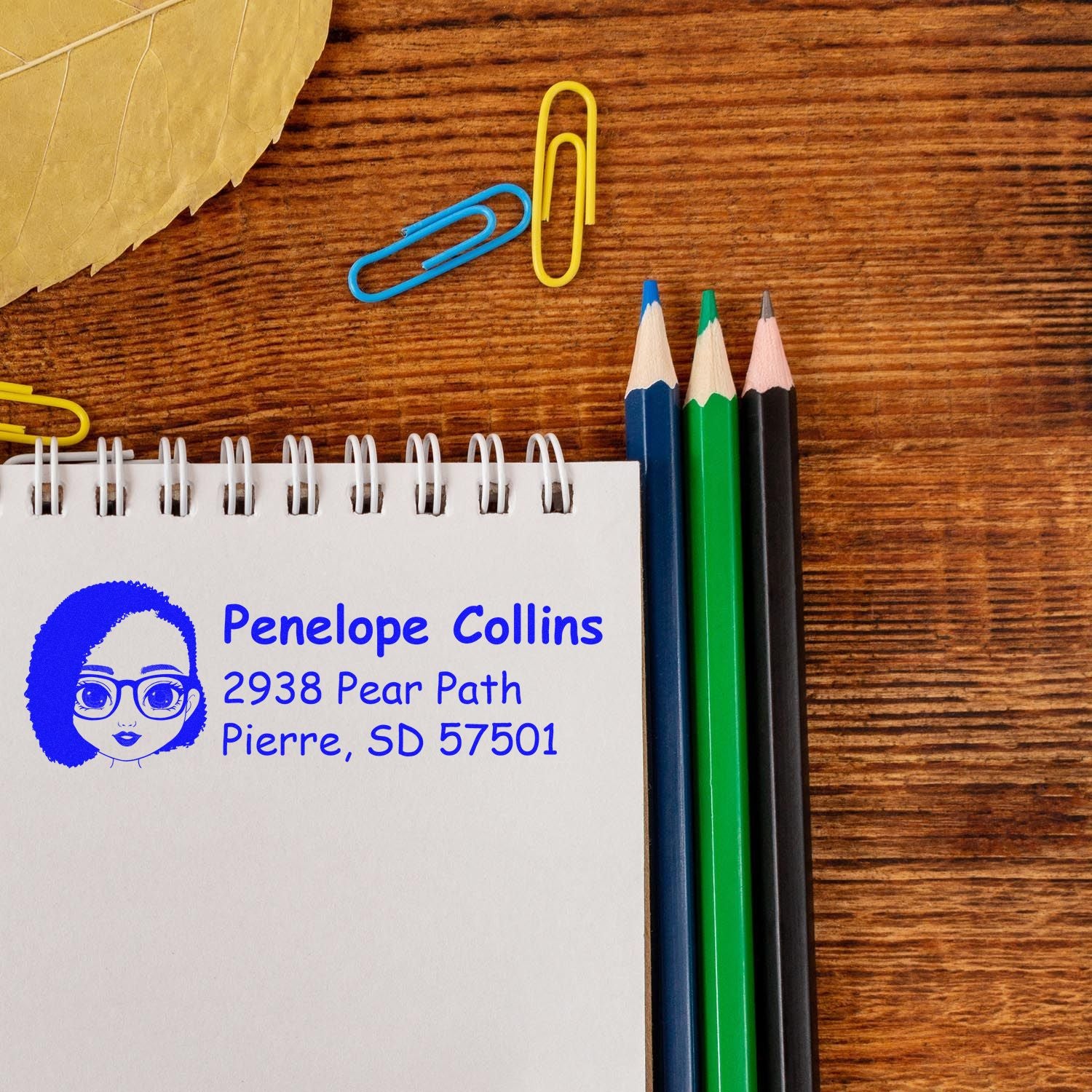 Custom address rubber stamp impression with name and home address on a notebook, ideal for personalized stationery and mail.