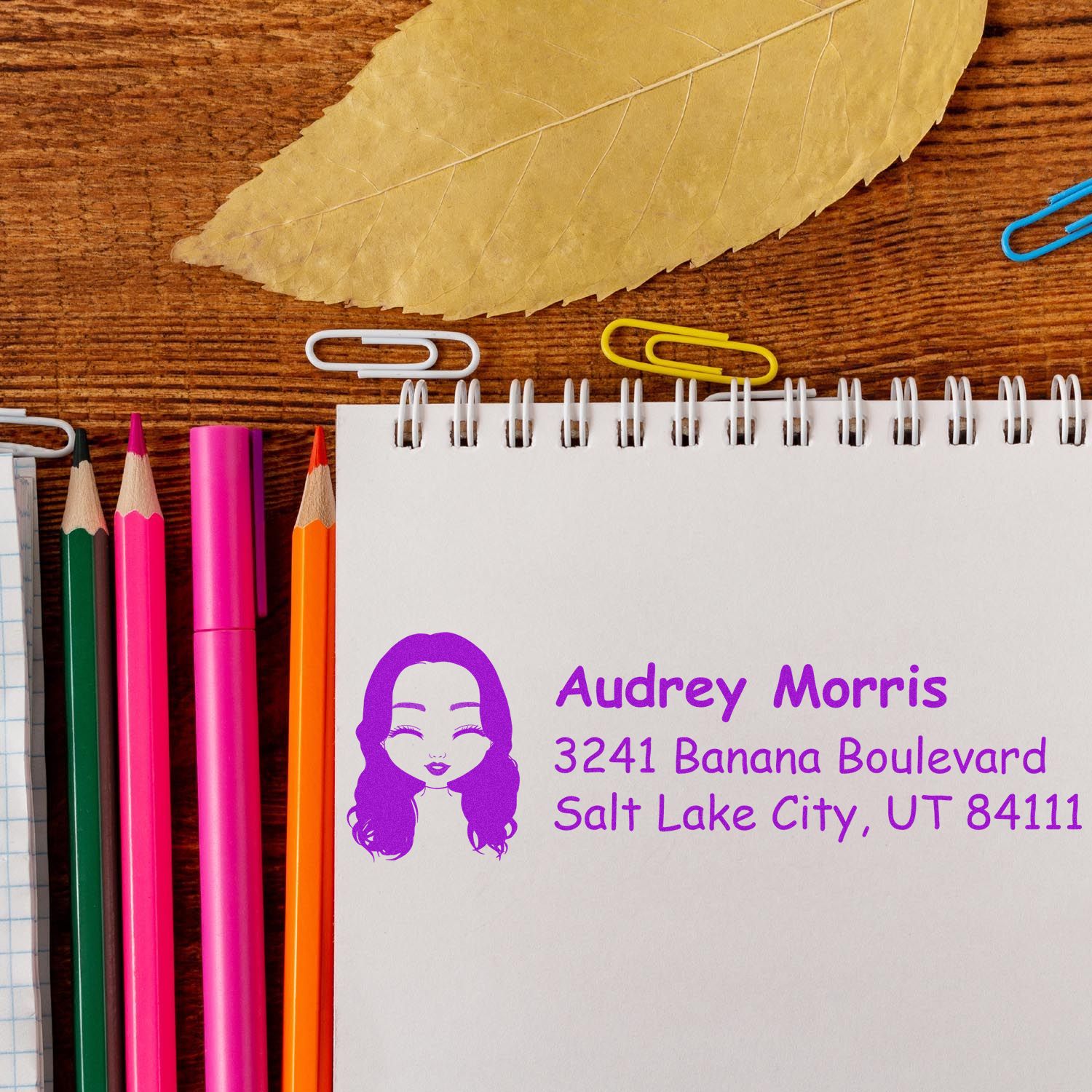 Custom address rubber stamp with name and mailing address on a notebook, ideal for personalized stationery and return mail.