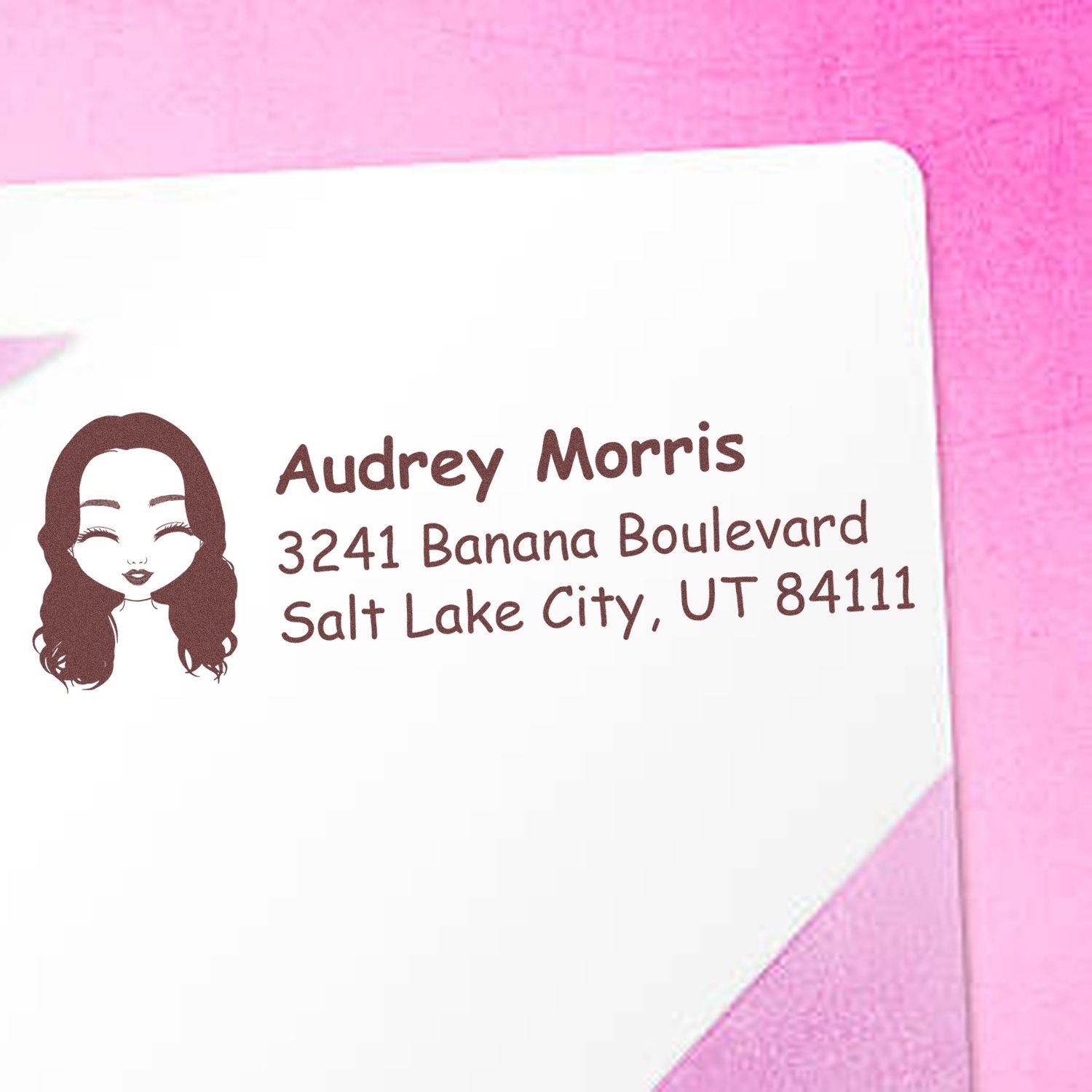 Custom return address rubber stamp with illustrated portrait on pink envelope, showing name and Salt Lake City address.