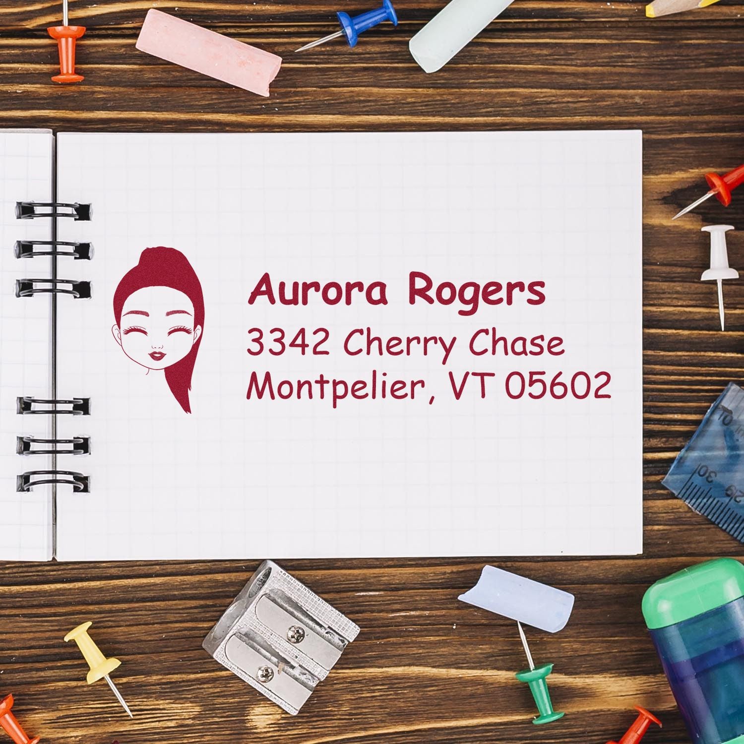Personalized return address rubber stamp with female logo, Aurora Rogers name, and Montpelier, VT mailing address.