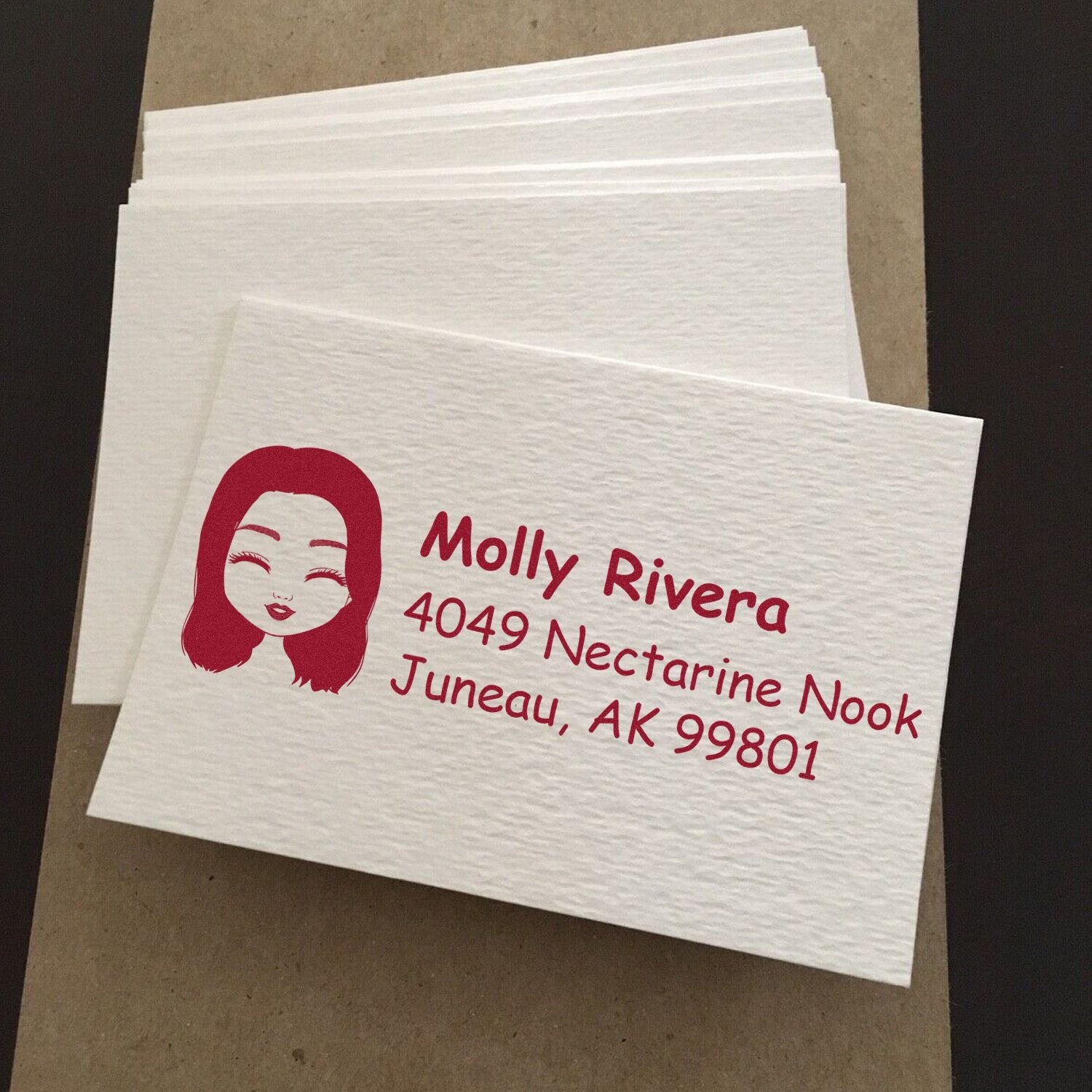 Custom rubber stamp return address on white envelopes, featuring a personalized name, address, and avatar logo.