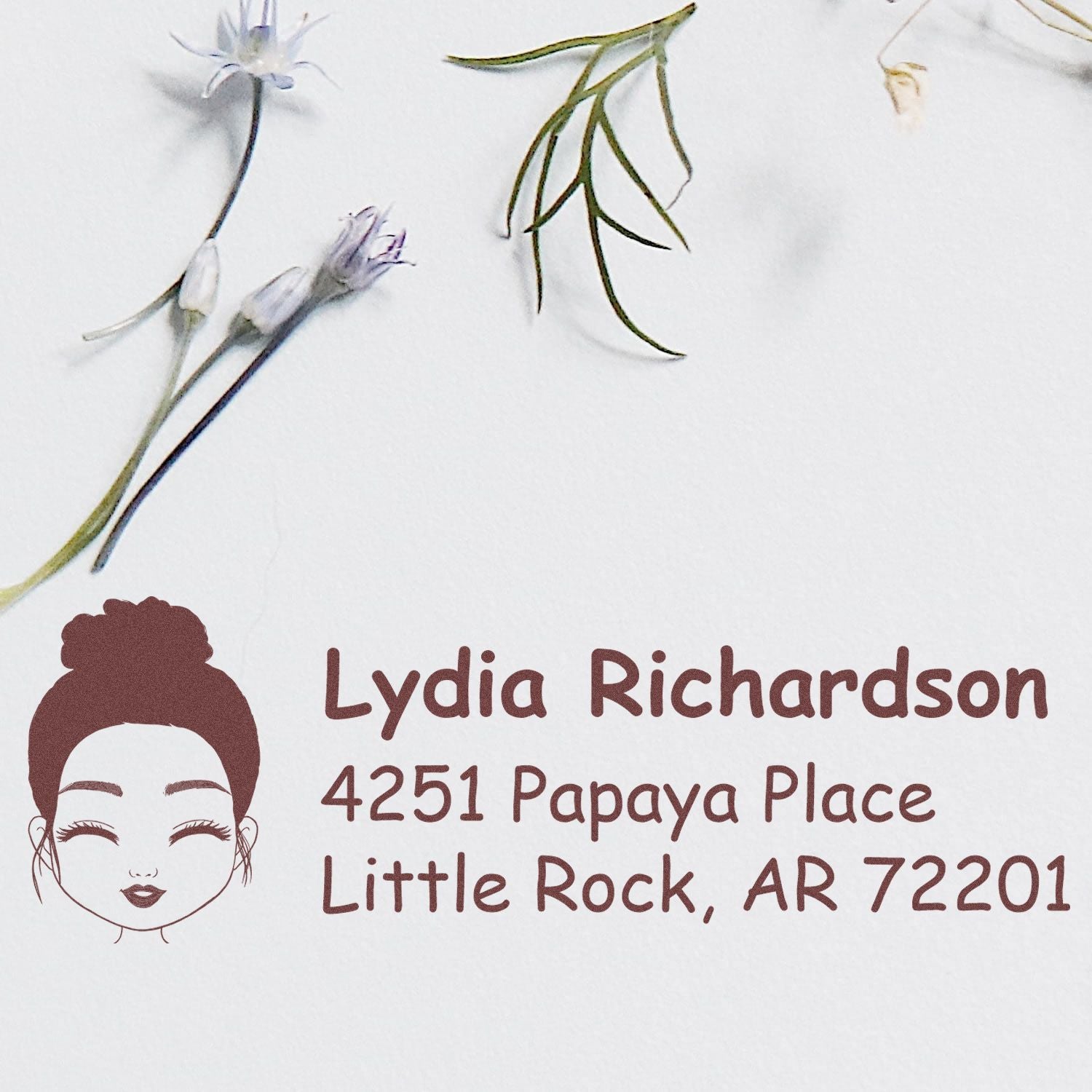Custom rubber return address stamp with floral design, woman icon, and Lydia Richardsons Little Rock, AR address.