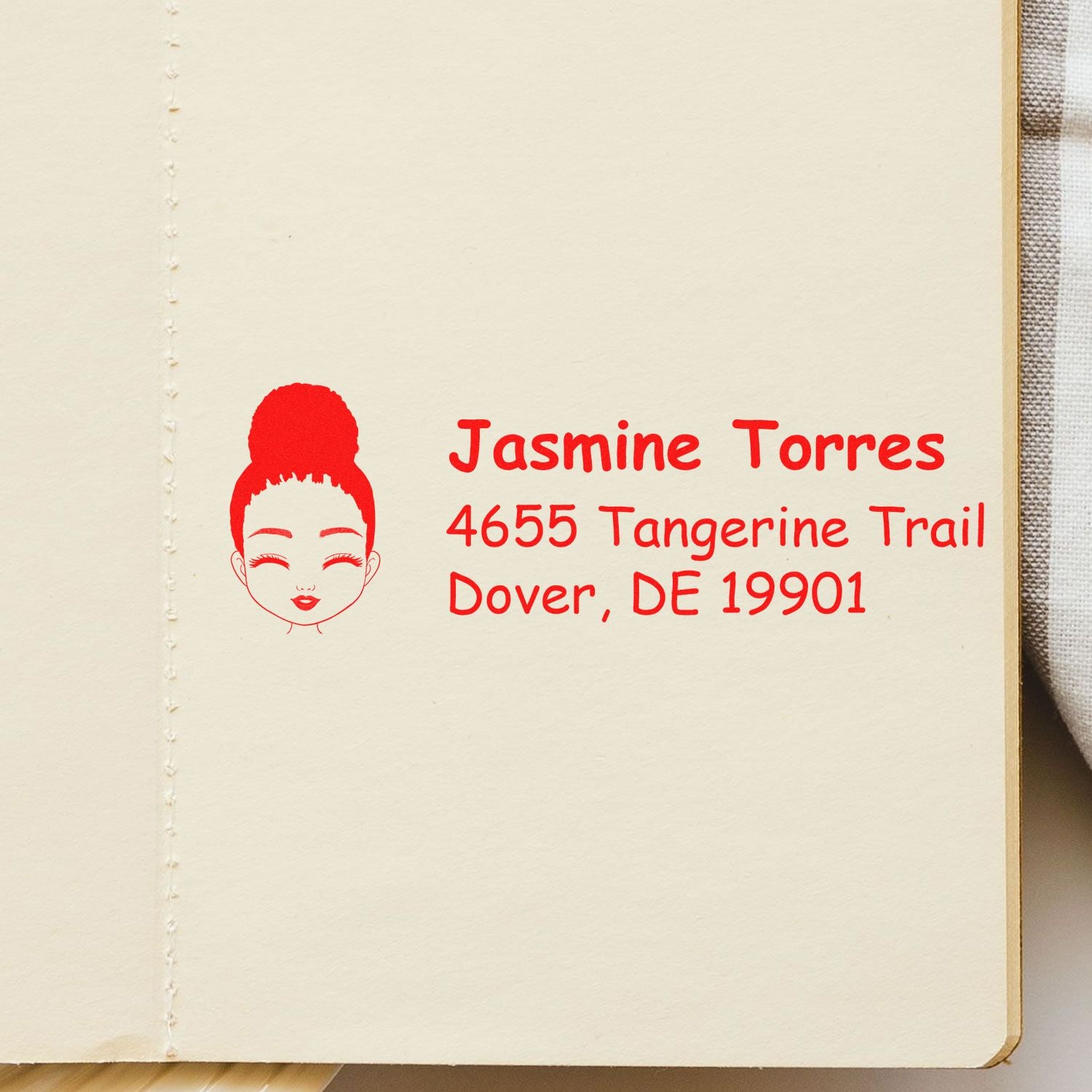 Custom rubber address stamp with female icon, showing Jasmine Torres, 4655 Tangerine Trail, Dover, DE 19901.