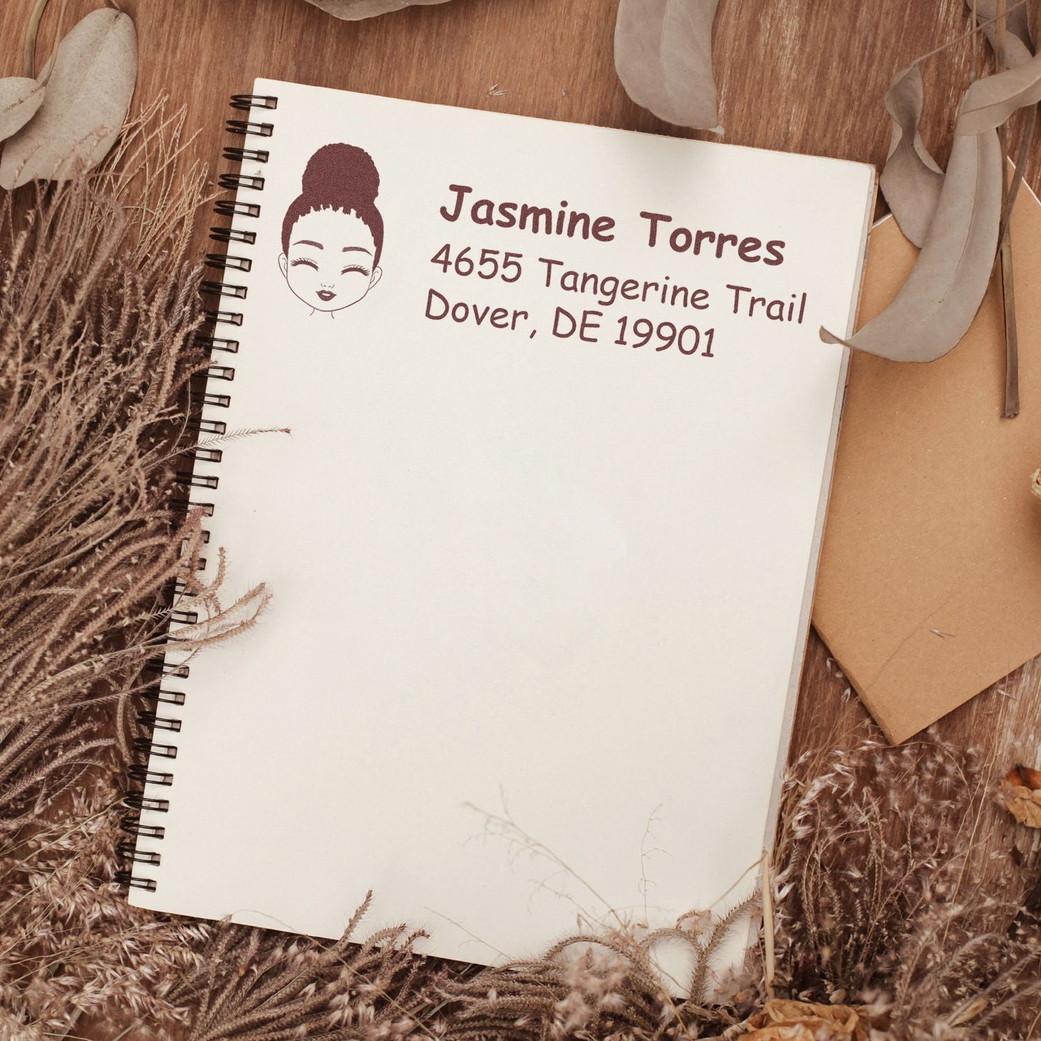 Personalized rubber address stamp with girl portrait, stamped on notebook with name and mailing address.