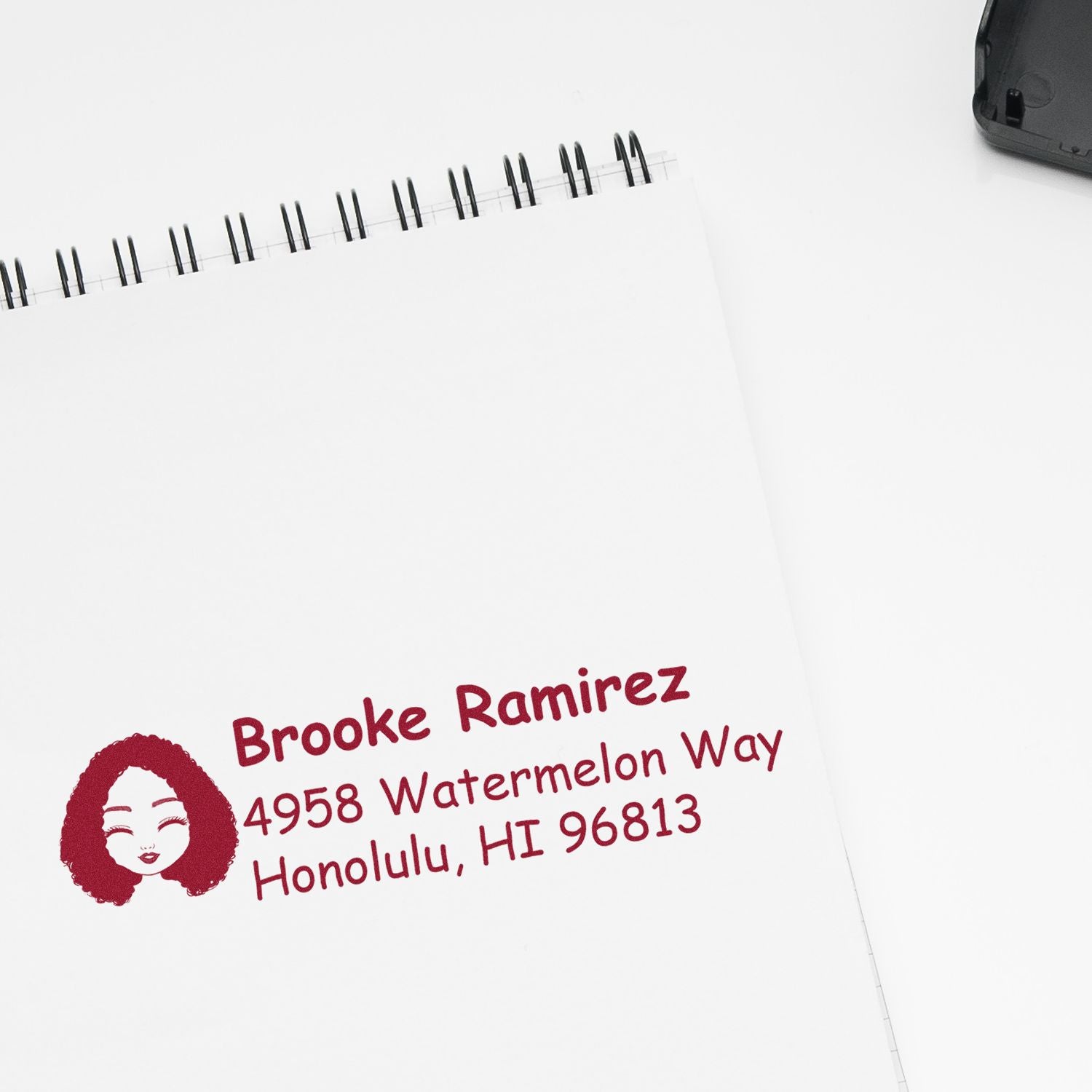 Custom return address rubber stamp with name and Honolulu, HI address on a notepad for mailing.