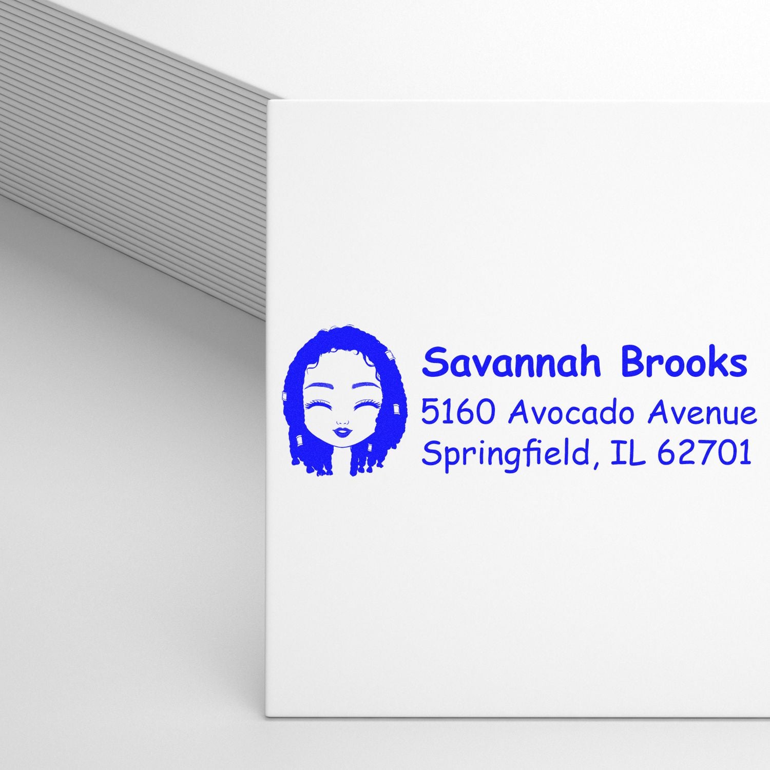Custom return address rubber stamp with name, address, and portrait icon for personalized envelope mailing.