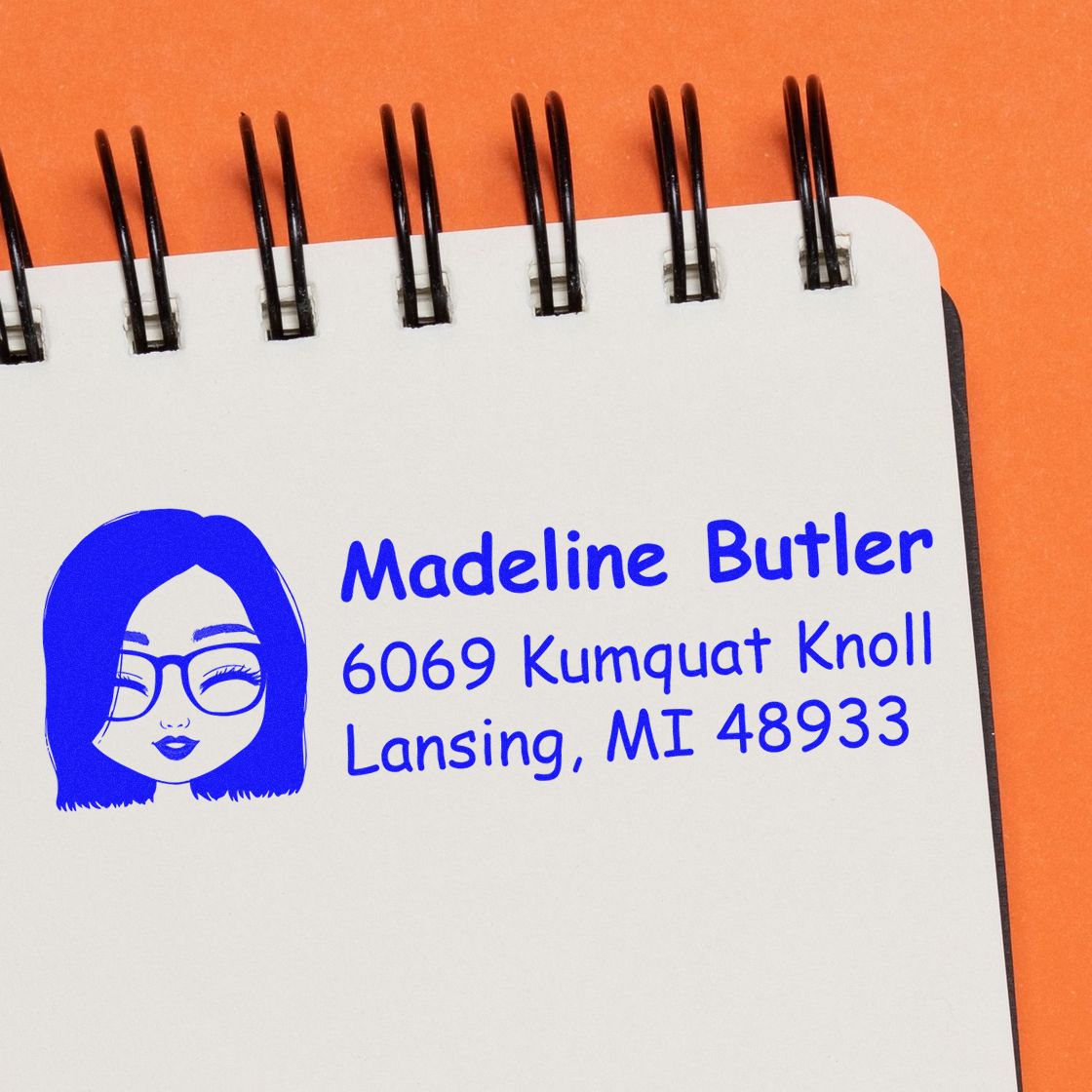 Custom return address rubber stamp with illustrated woman logo, Madeline Butler, Lansing, MI, in blue ink.