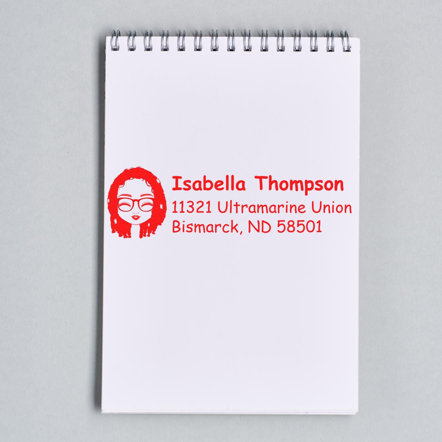 Personalized rubber address stamp with name and return address printed on a notepad