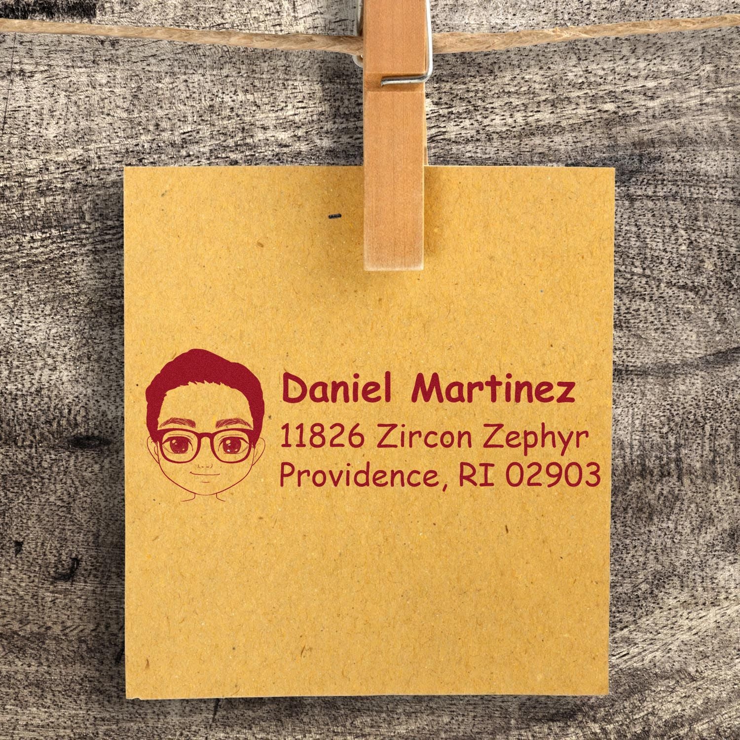 Personalized rubber return address stamp with name, address, and avatar on kraft paper.