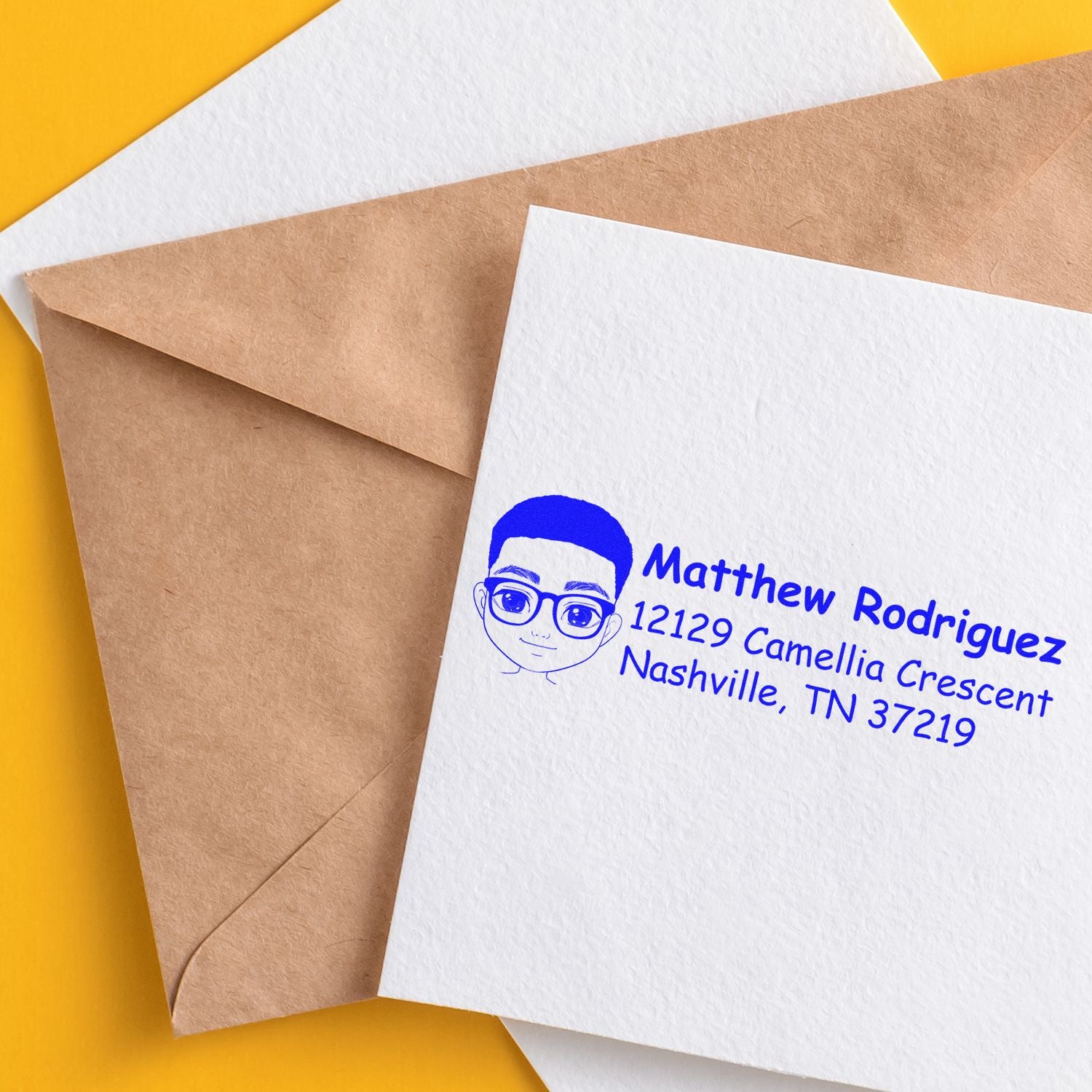 Personalized return address rubber stamp on envelope with cartoon portrait, blue ink, for custom mailing.