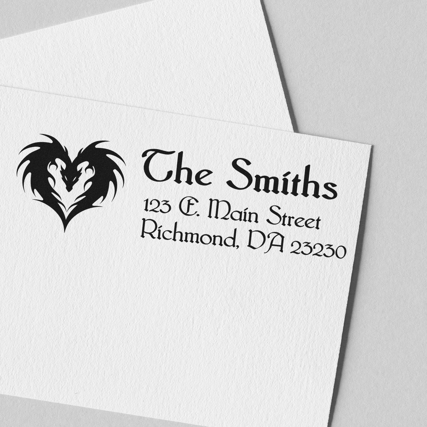 Custom family return address rubber stamp for The Smiths with dragon heart logo on stationery.