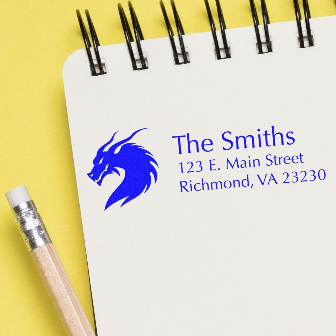 Custom rubber address stamp with dragon logo and The Smiths return address on notebook page.