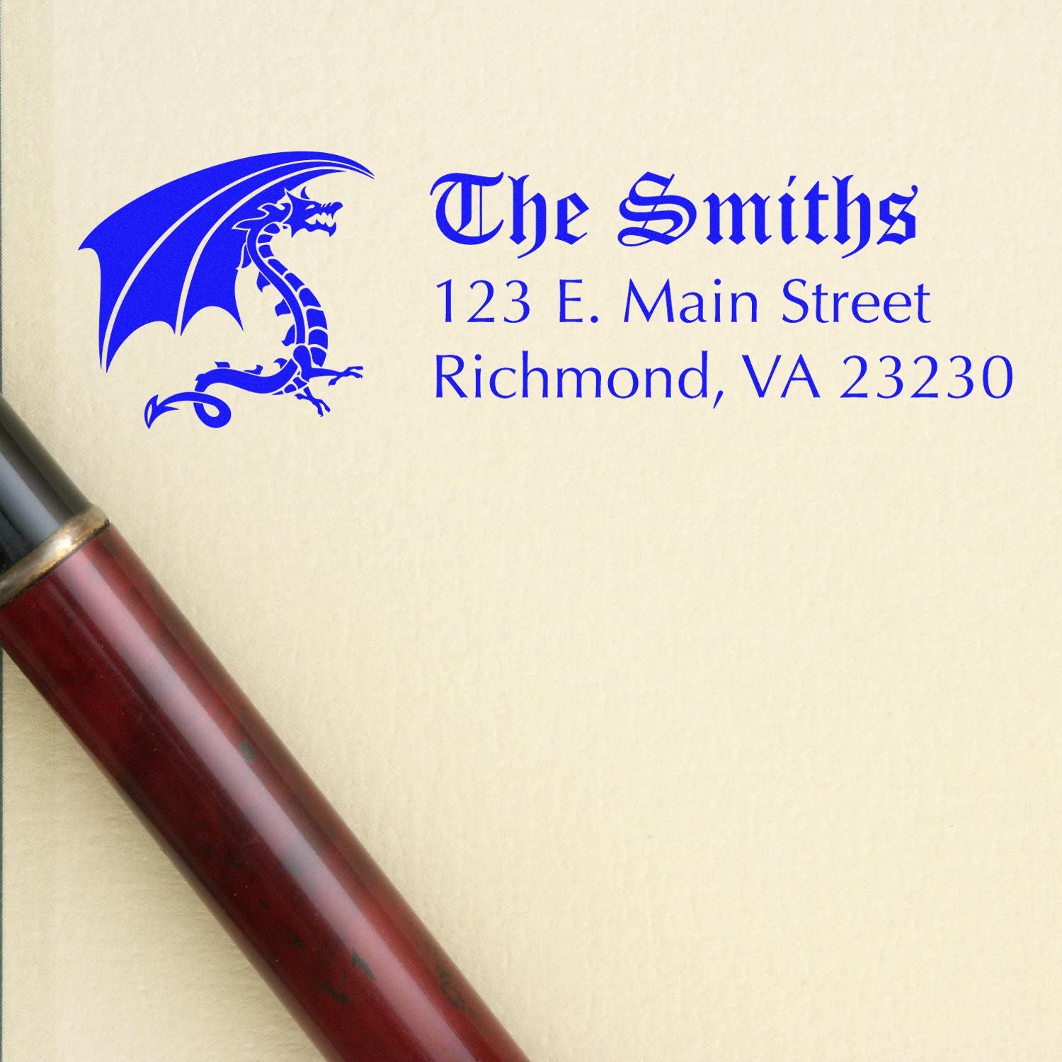 Custom business address rubber stamp for The Smiths with dragon logo and Richmond, VA 23230 in blue ink.