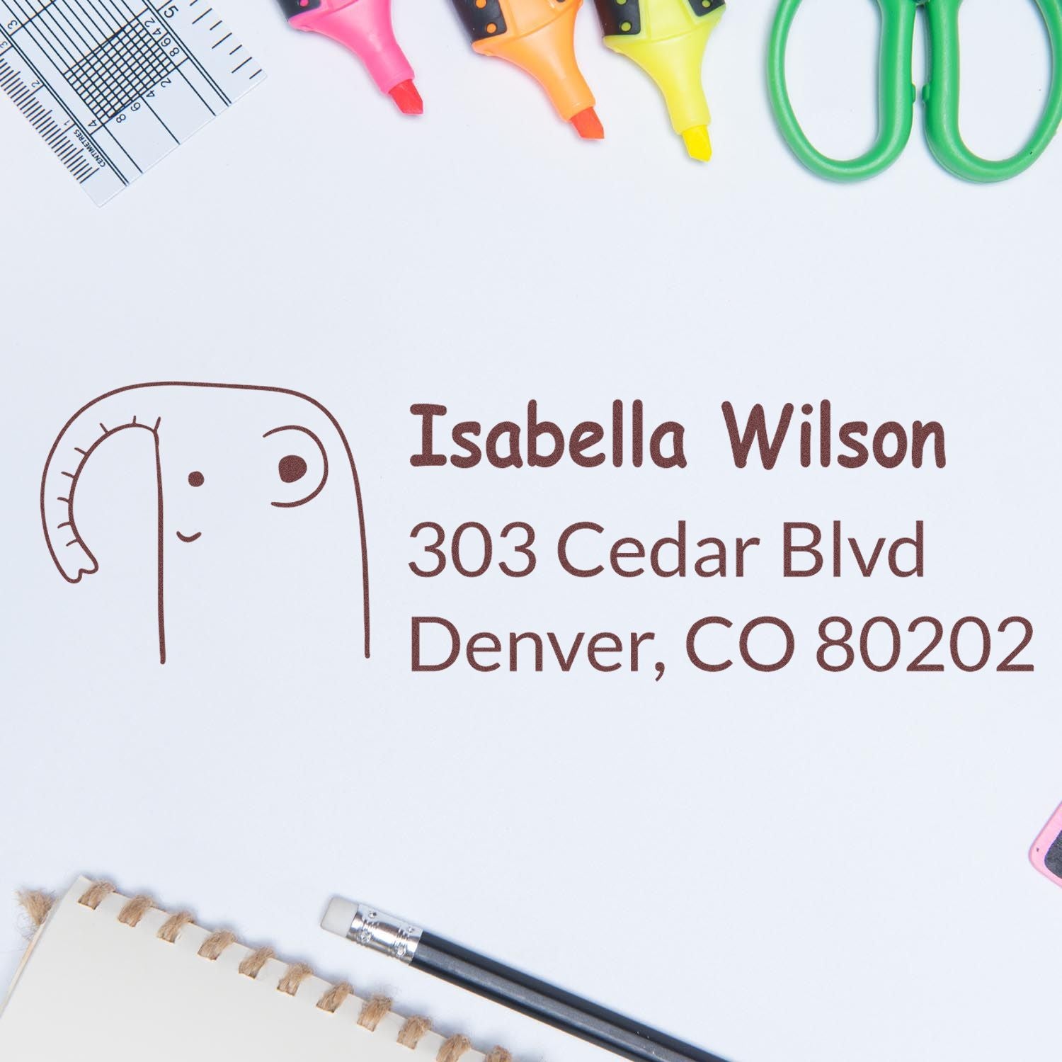 Custom rubber address stamp with name and Denver address, featuring a playful face design for stationery and packaging.