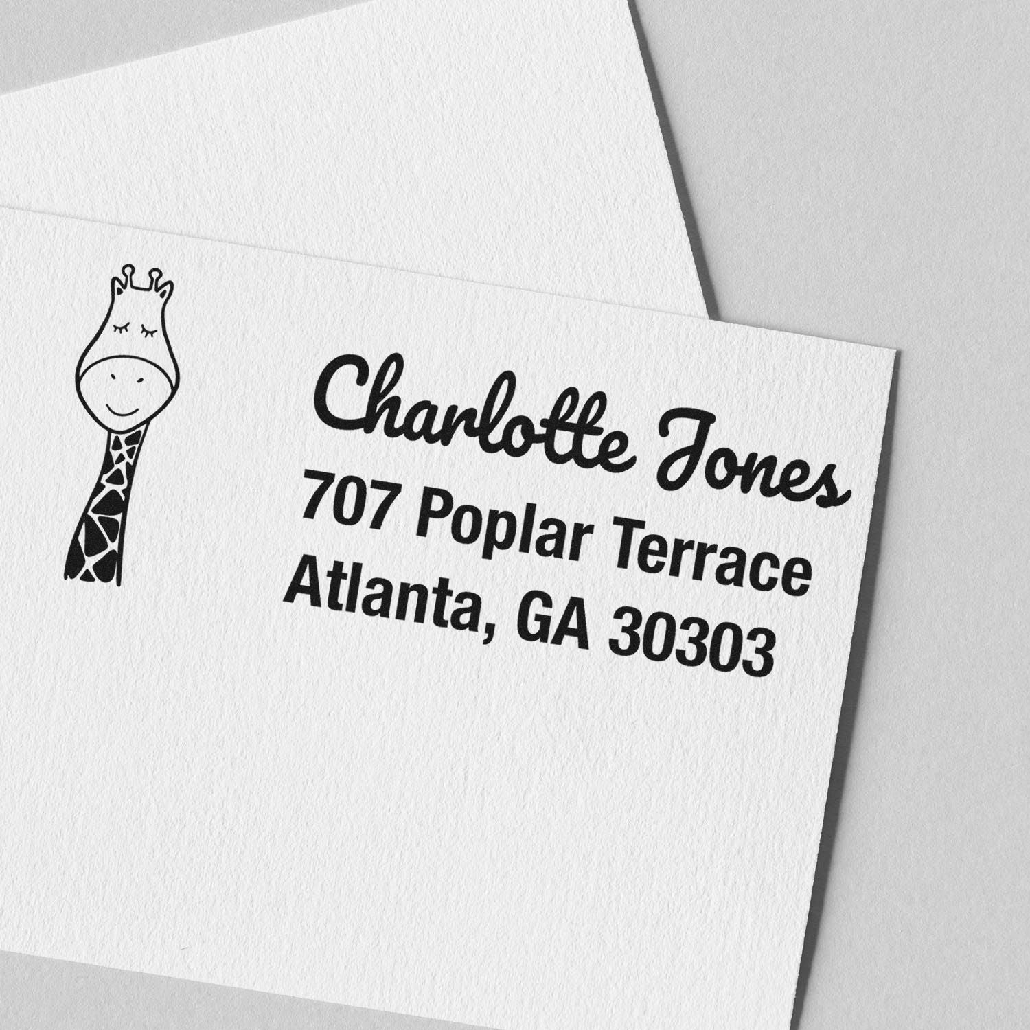 Custom rubber address stamp with giraffe design for Charlotte Jones, Atlanta, GA 30303